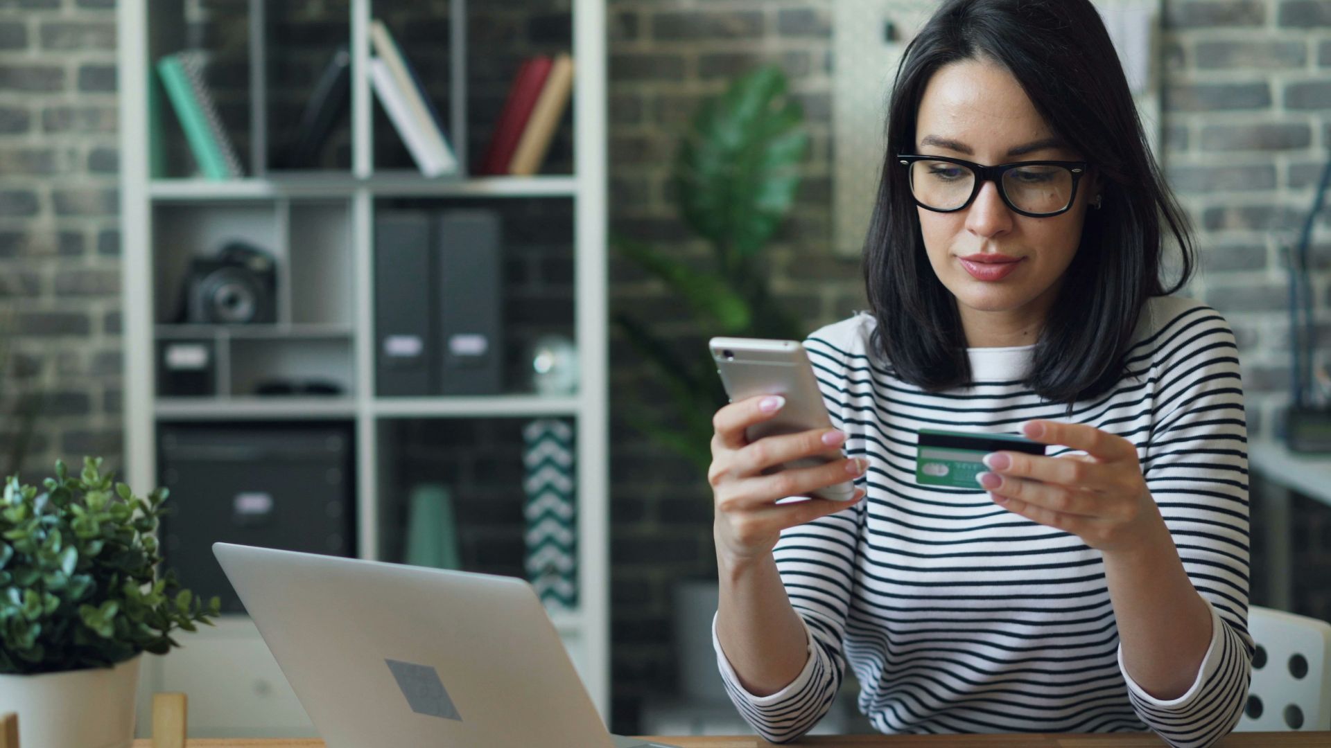a woman sitting at a table looking at her cell phone