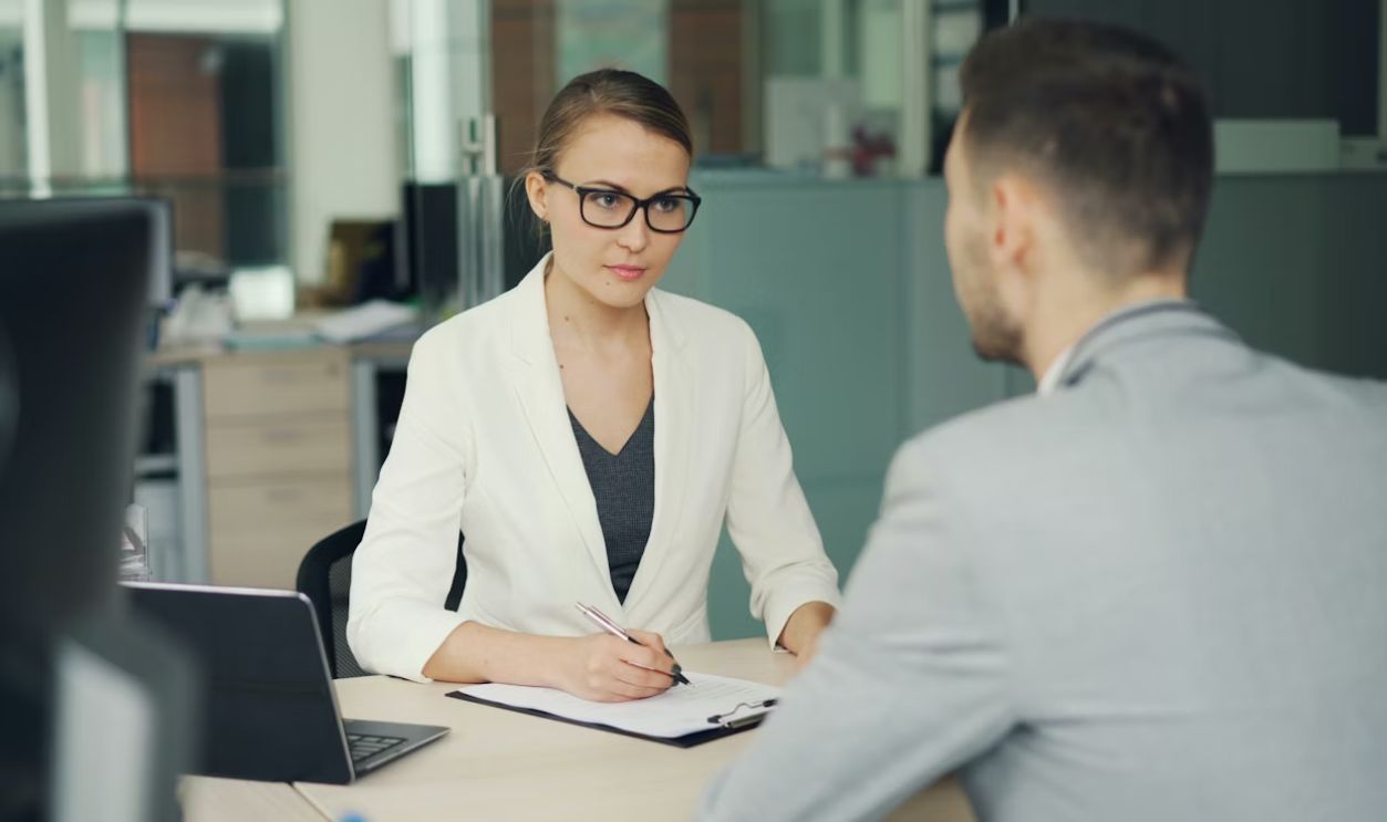 Customer calmly speaking with a bank teller at the counter