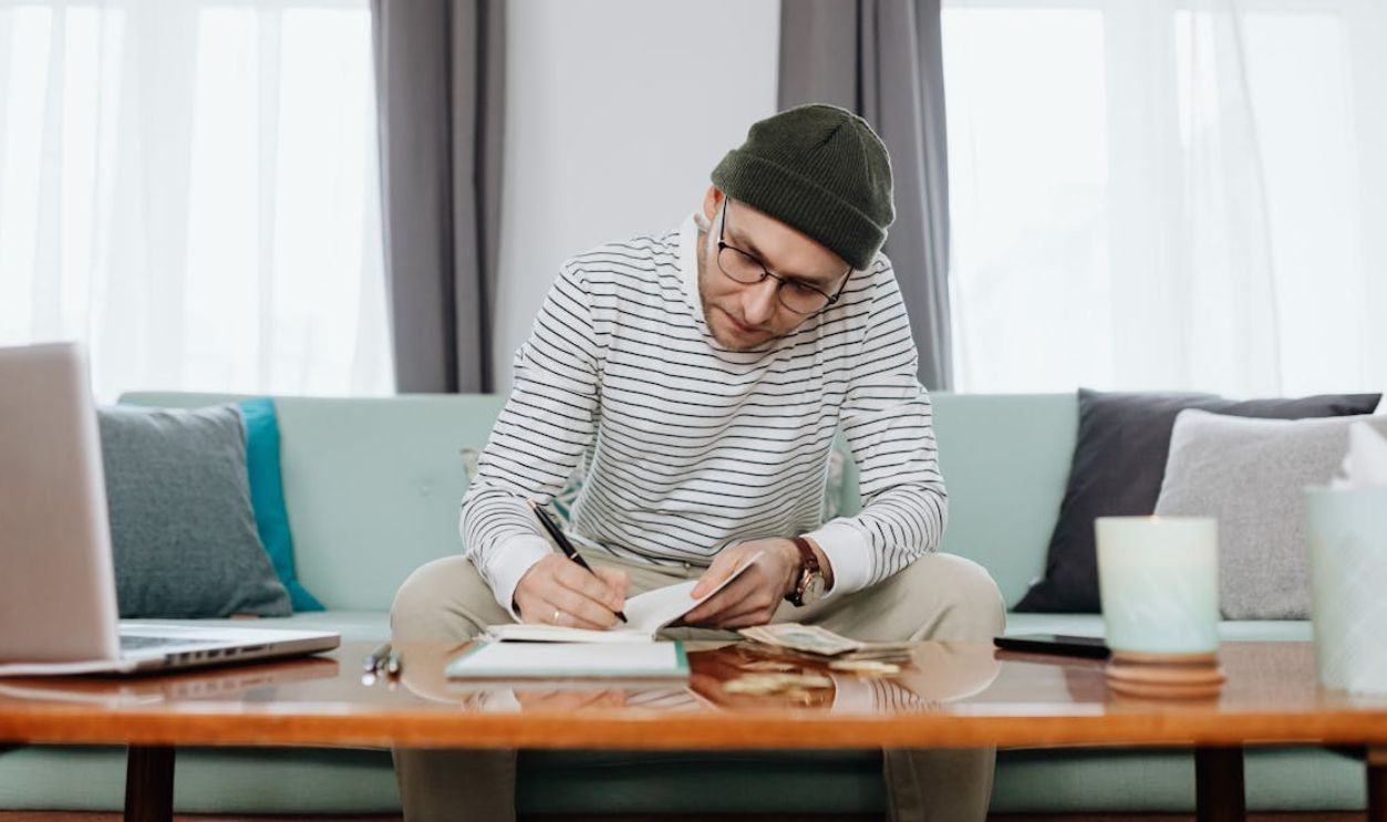 Woman in White and Black Stripe Long Sleeve Shirt Sitting on Blue Couch