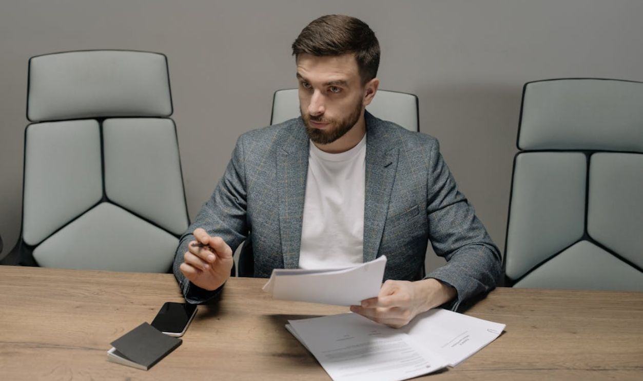 Bearded Man Wearing Suit Jacket Holding Papers