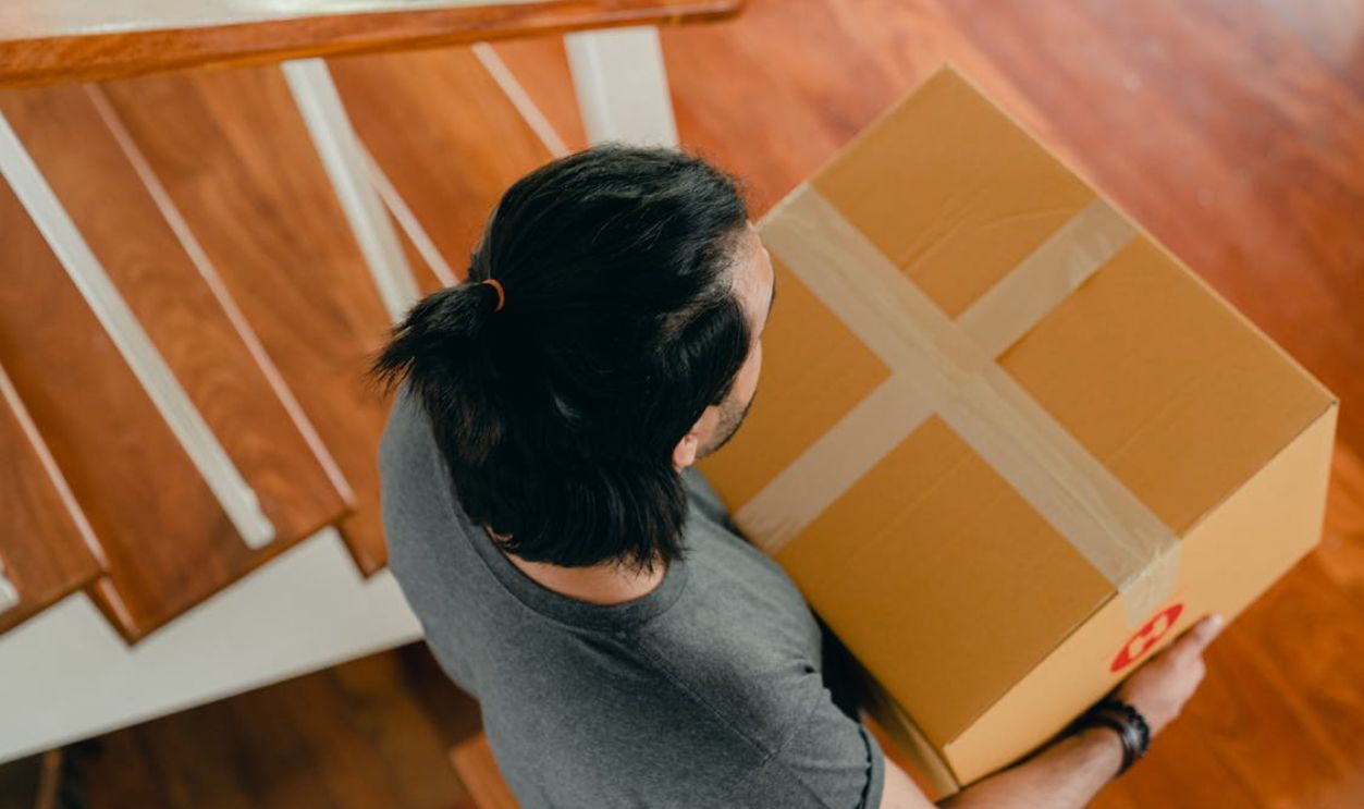 Man carrying box in new apartment