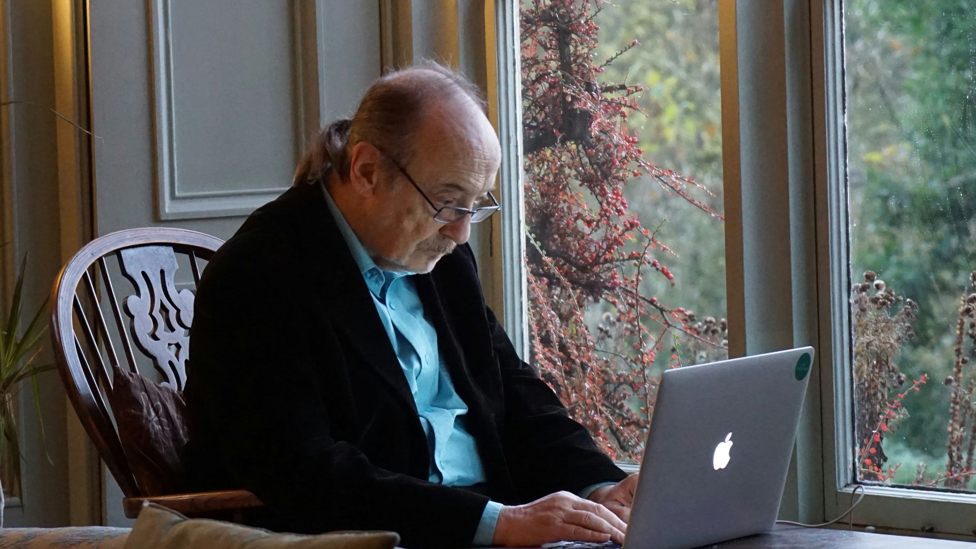 man in black suit jacket using macbook