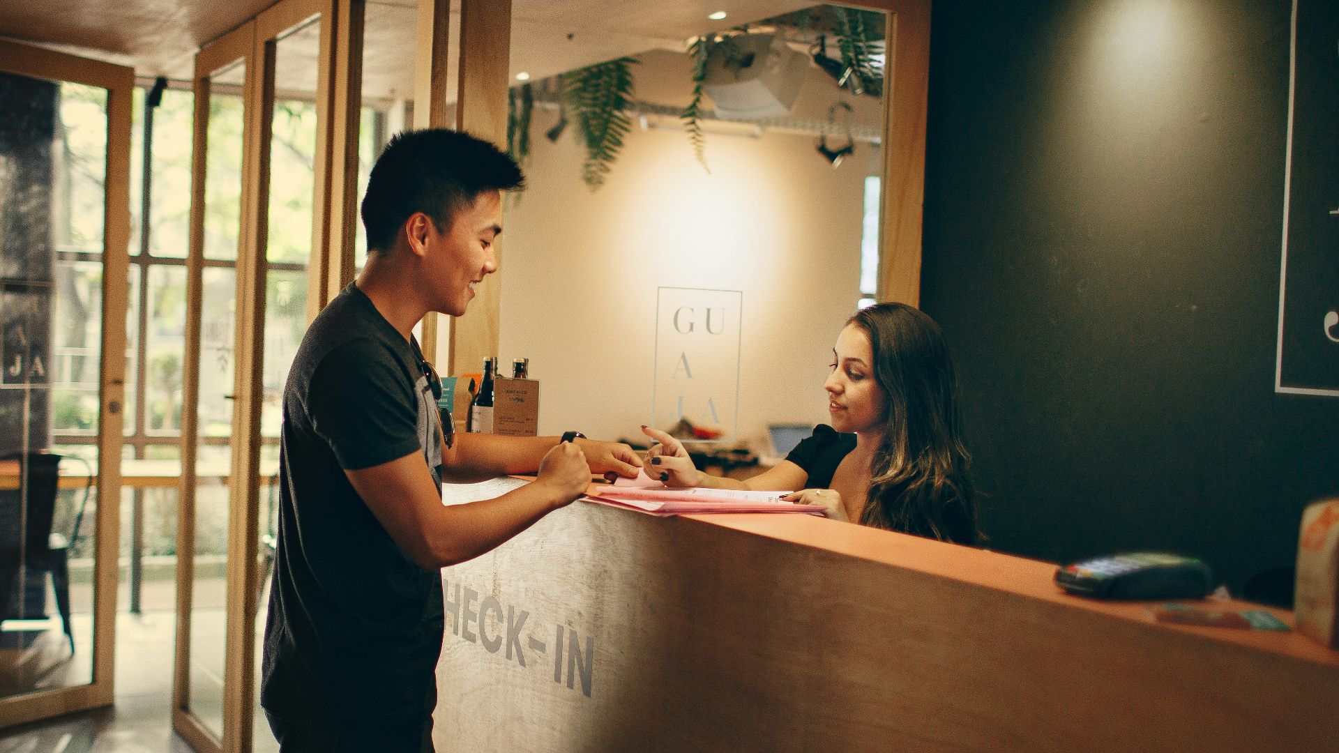 man in black shirt standing beside counter