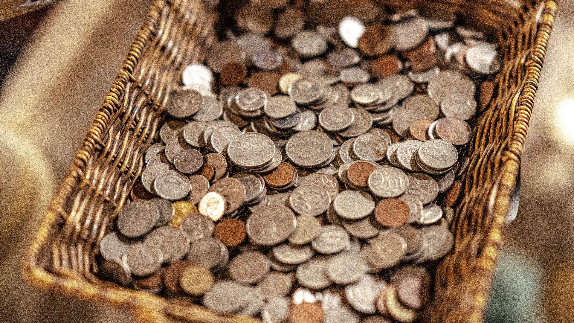 a basket filled with lots of coins sitting on top of a table