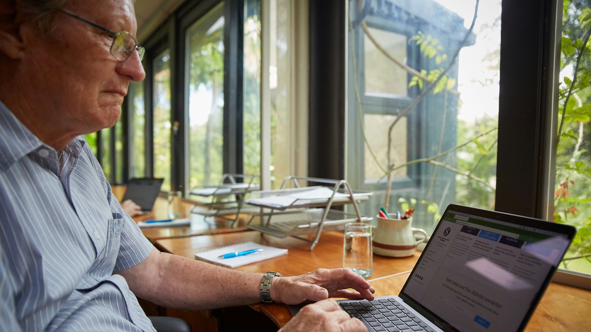 a man sitting at a table using a laptop computer