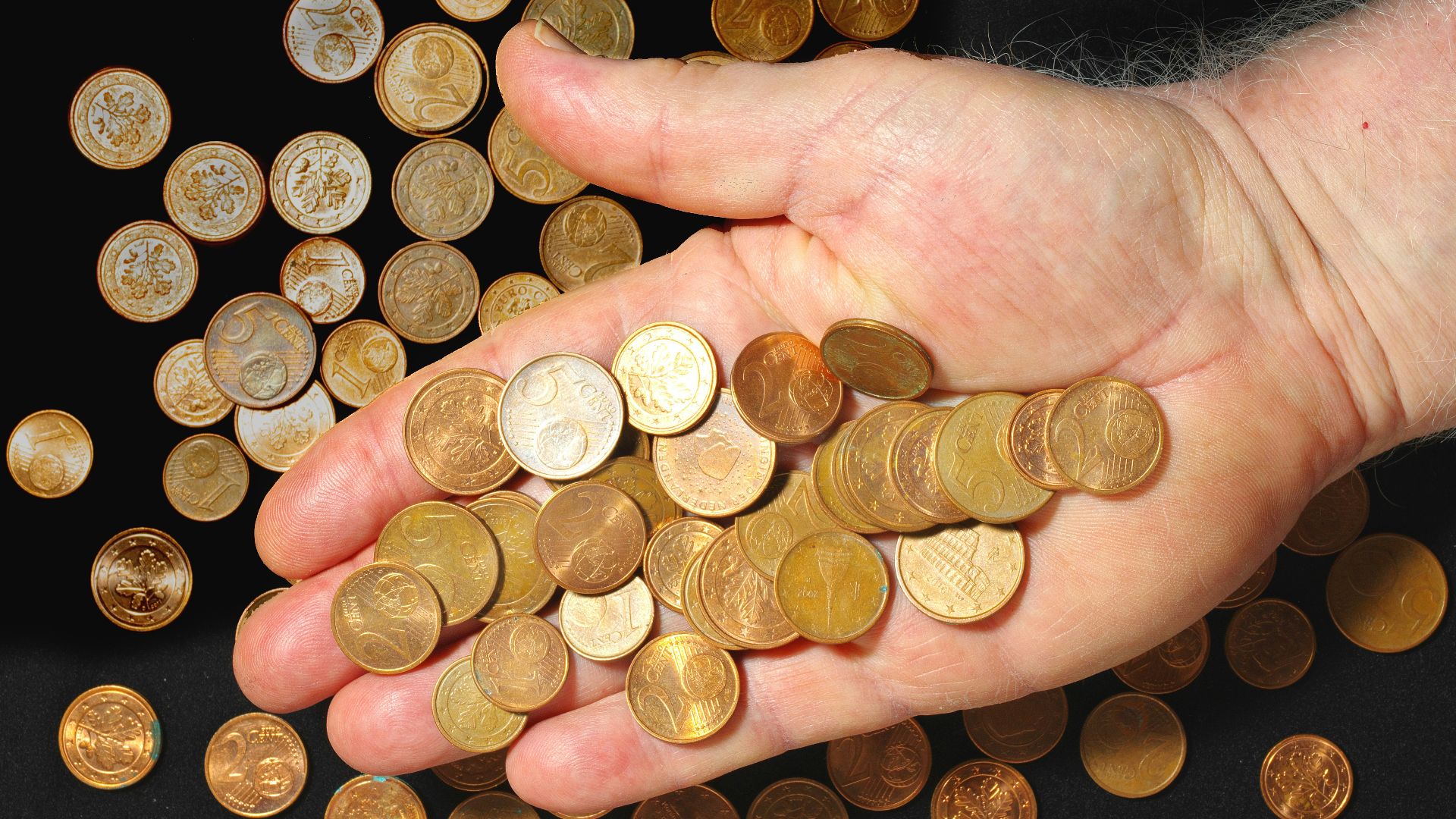 Coins are held in a hand.