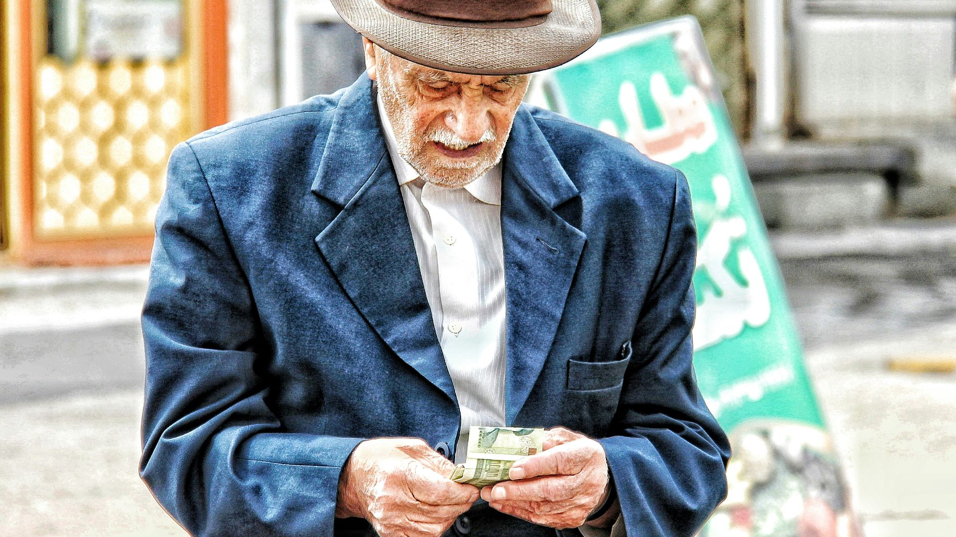 a man in a hat holding a glass of beer
