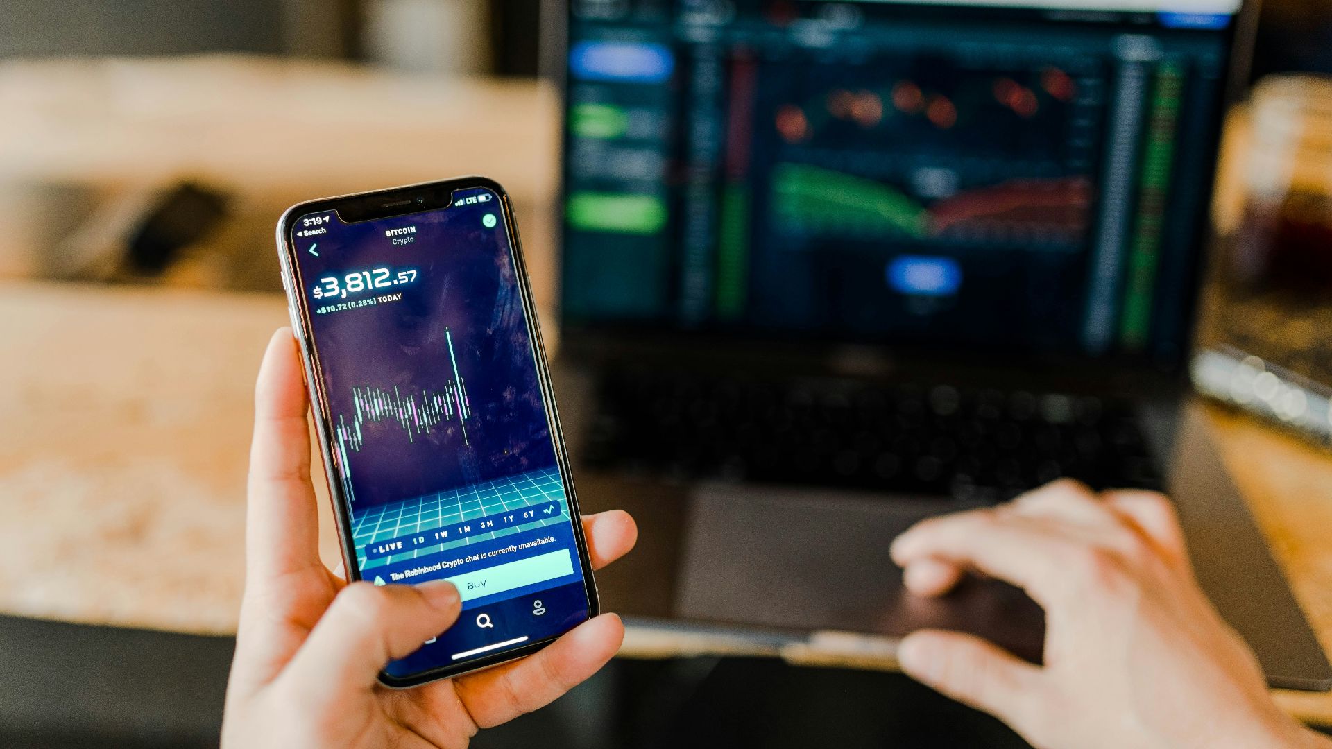 person using phone and laptop computer