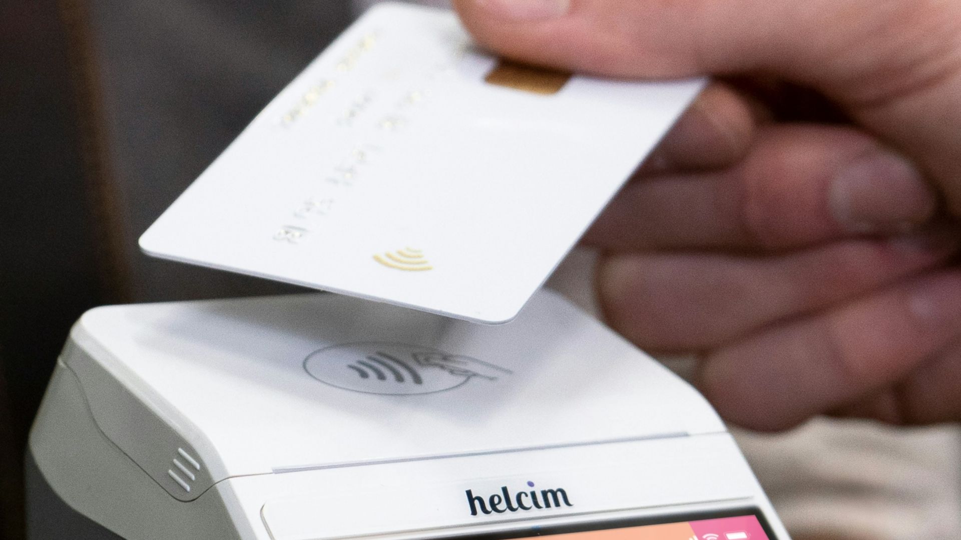 a person holding a smart phone with a credit card on top of it