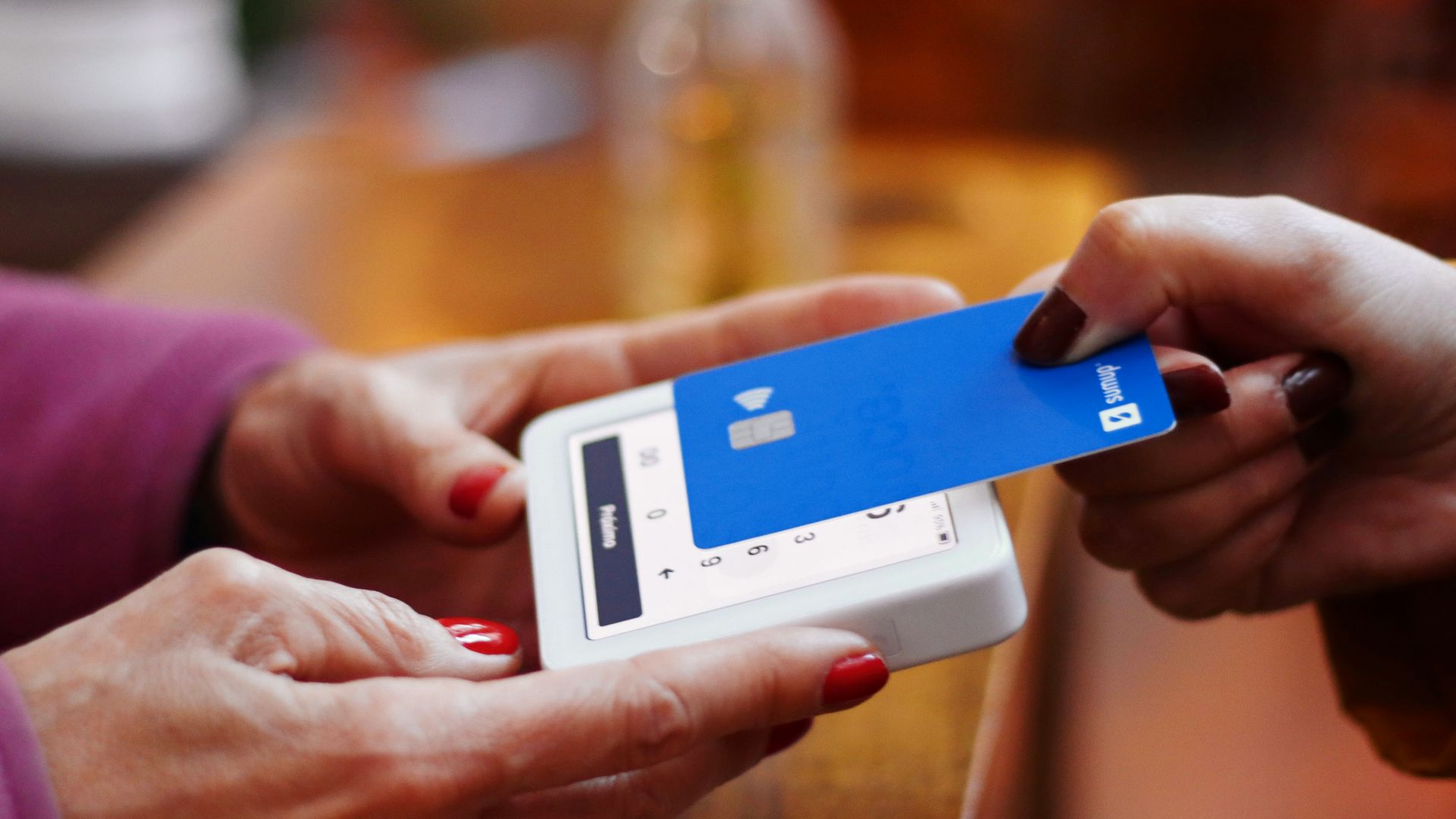 a person holding a credit card and a cell phone