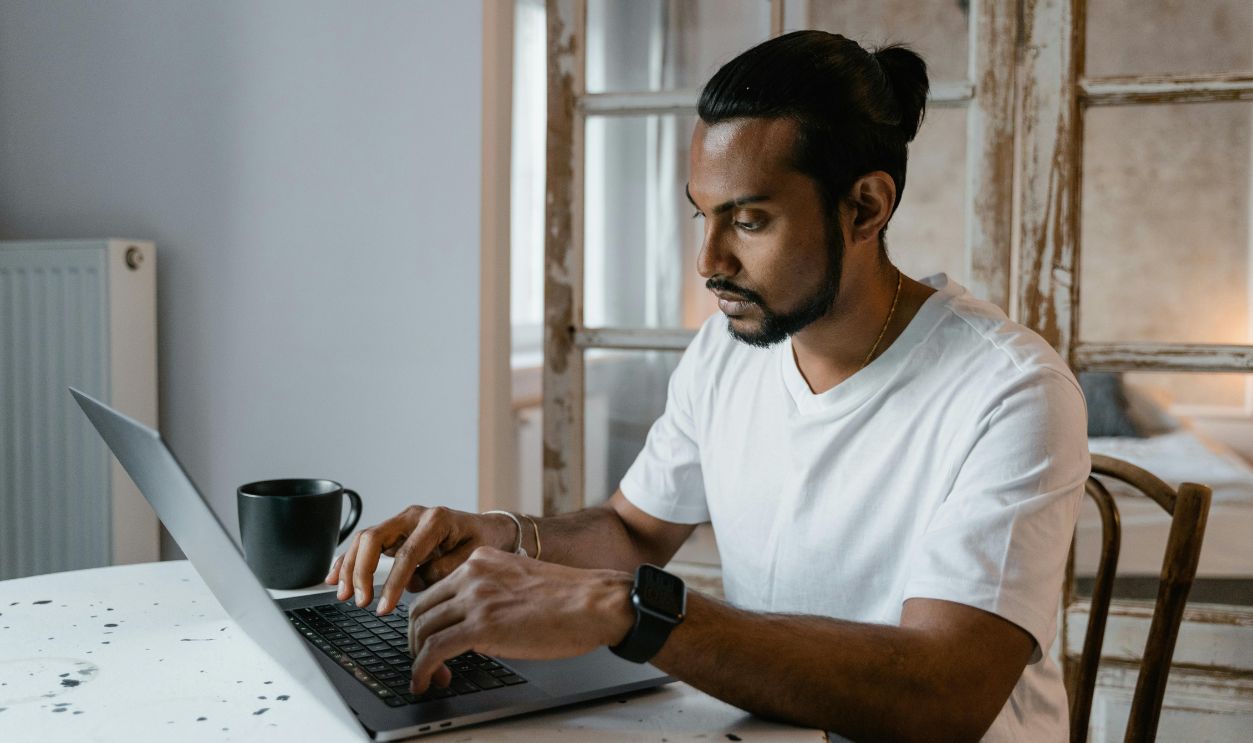 A Man Typing on a Laptop