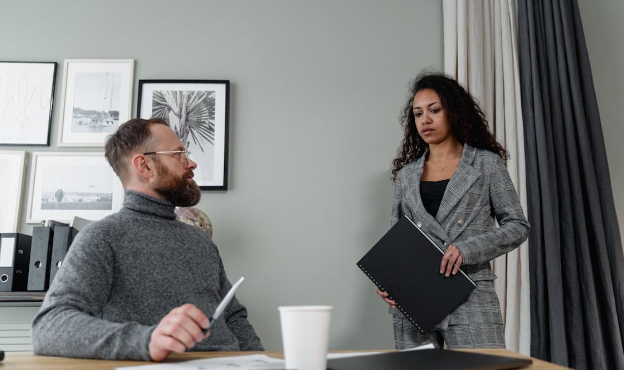 A Low Angle Shot of a Man and Woman Having Conversation Inside the Office