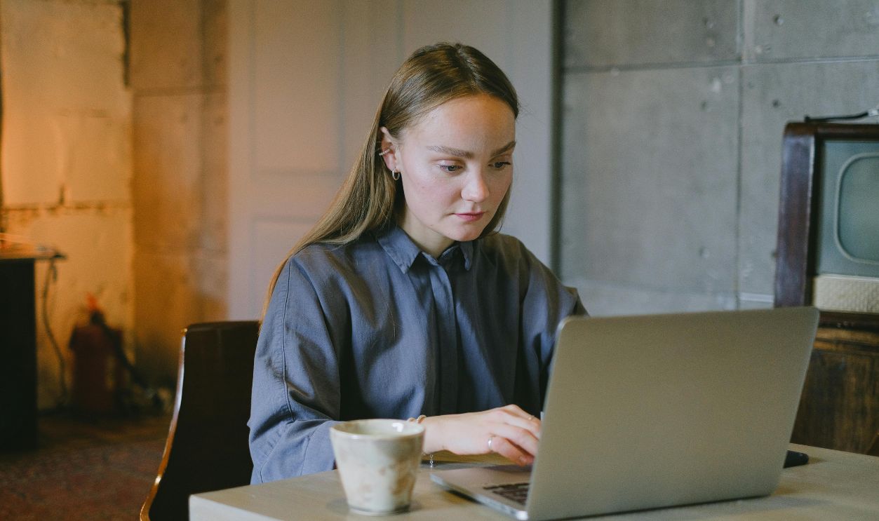 Serious female freelancer using netbook in workspace