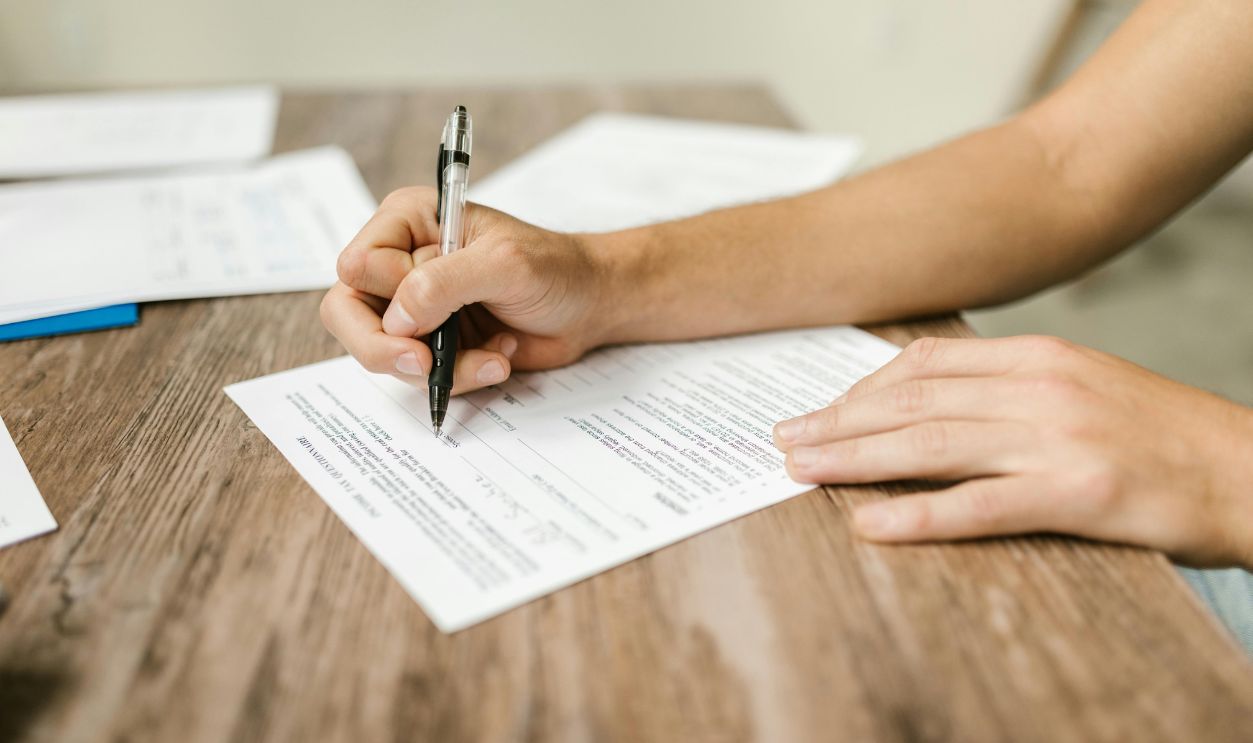 Close-Up Shot of a Person Filling Out a Form