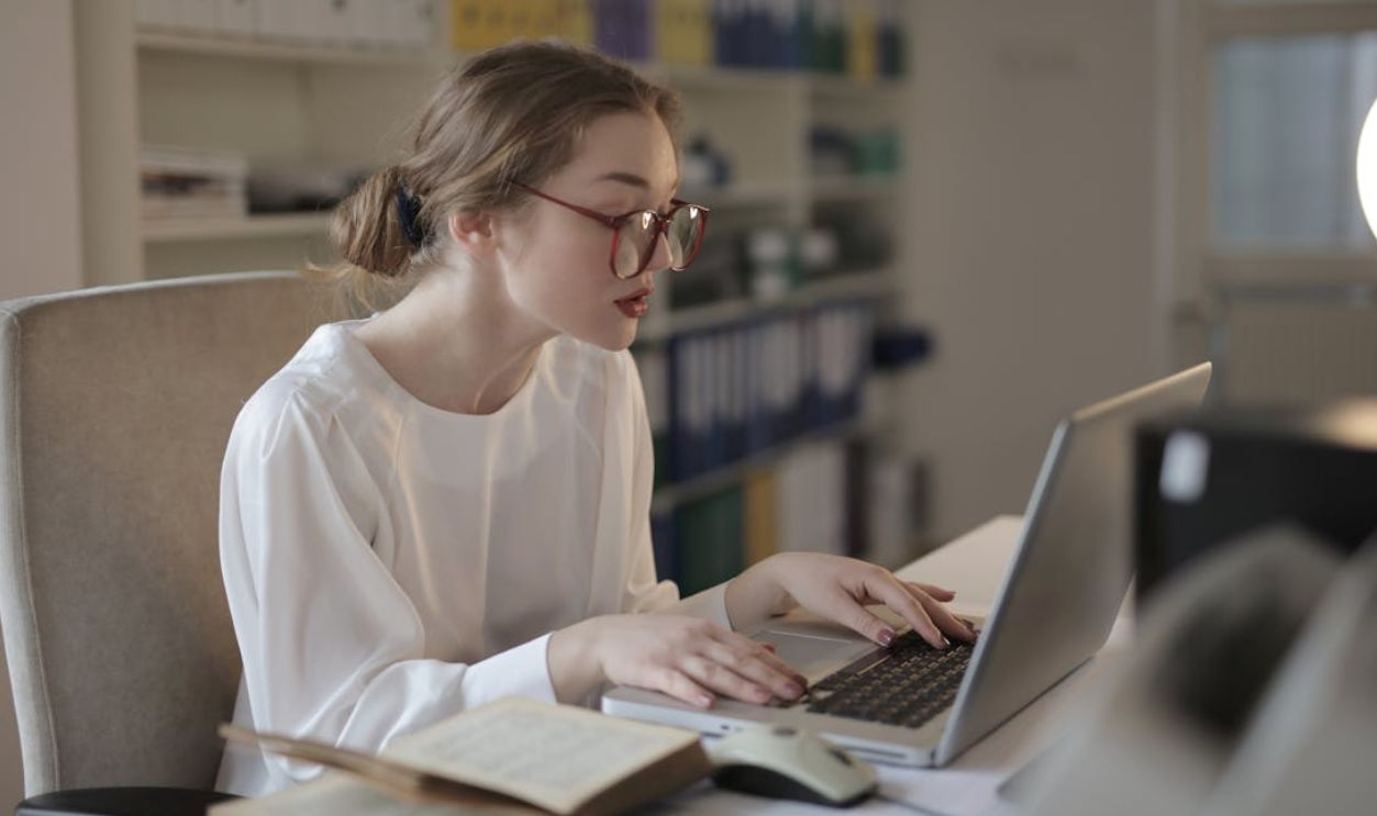 Woman In White Dress Shirt Using A Laptop