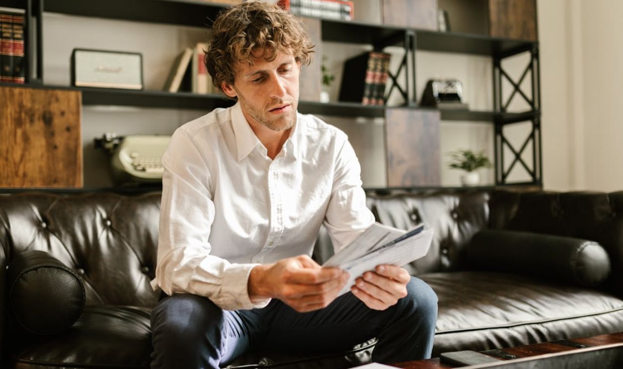 Man in White Long Sleeve Shirt Sitting on Sofa