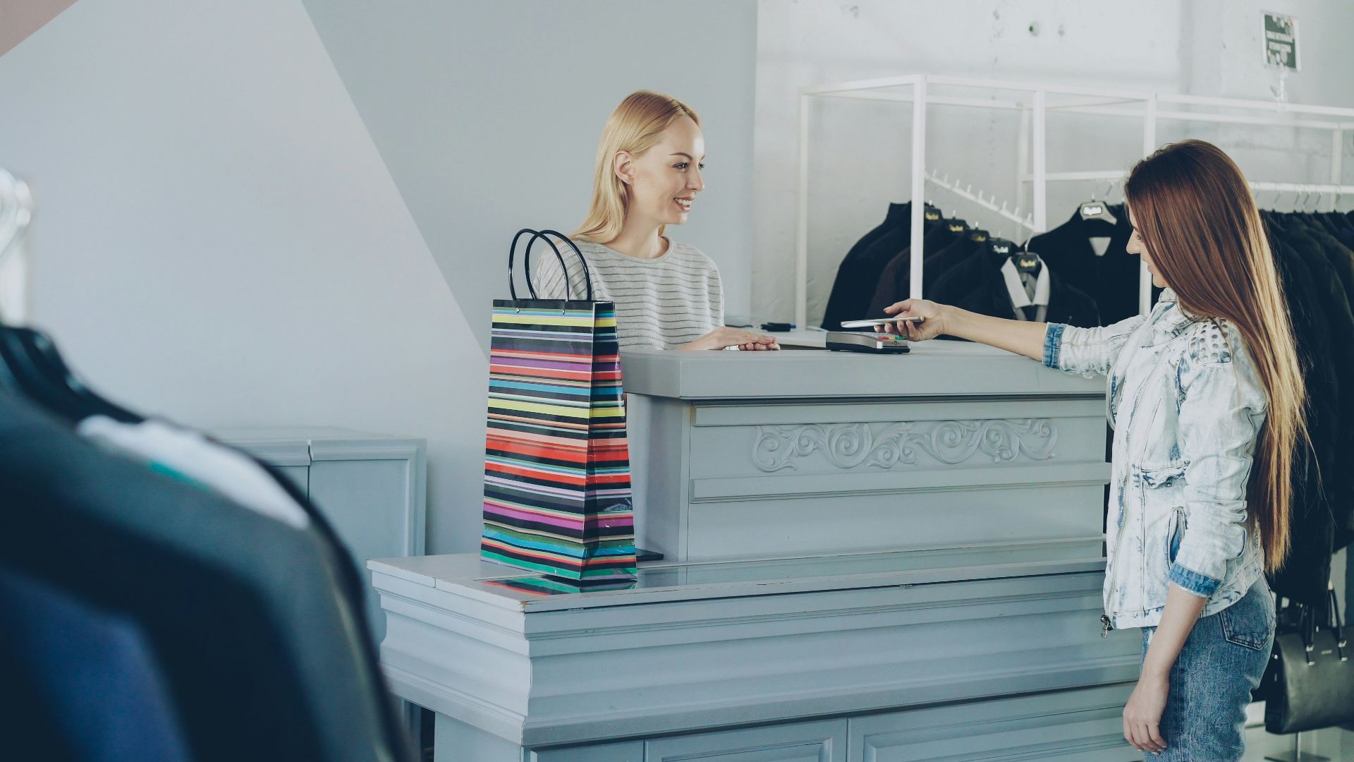 A girl pays for purchases at a clothing store.