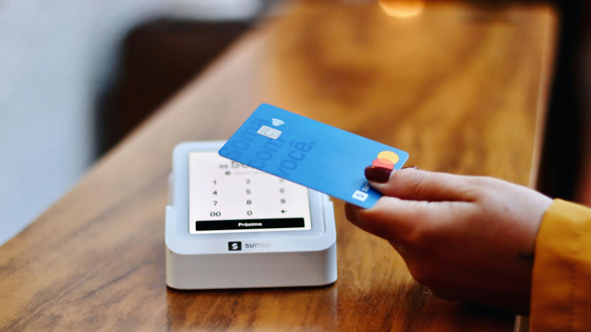 a person holding a credit card in front of a machine