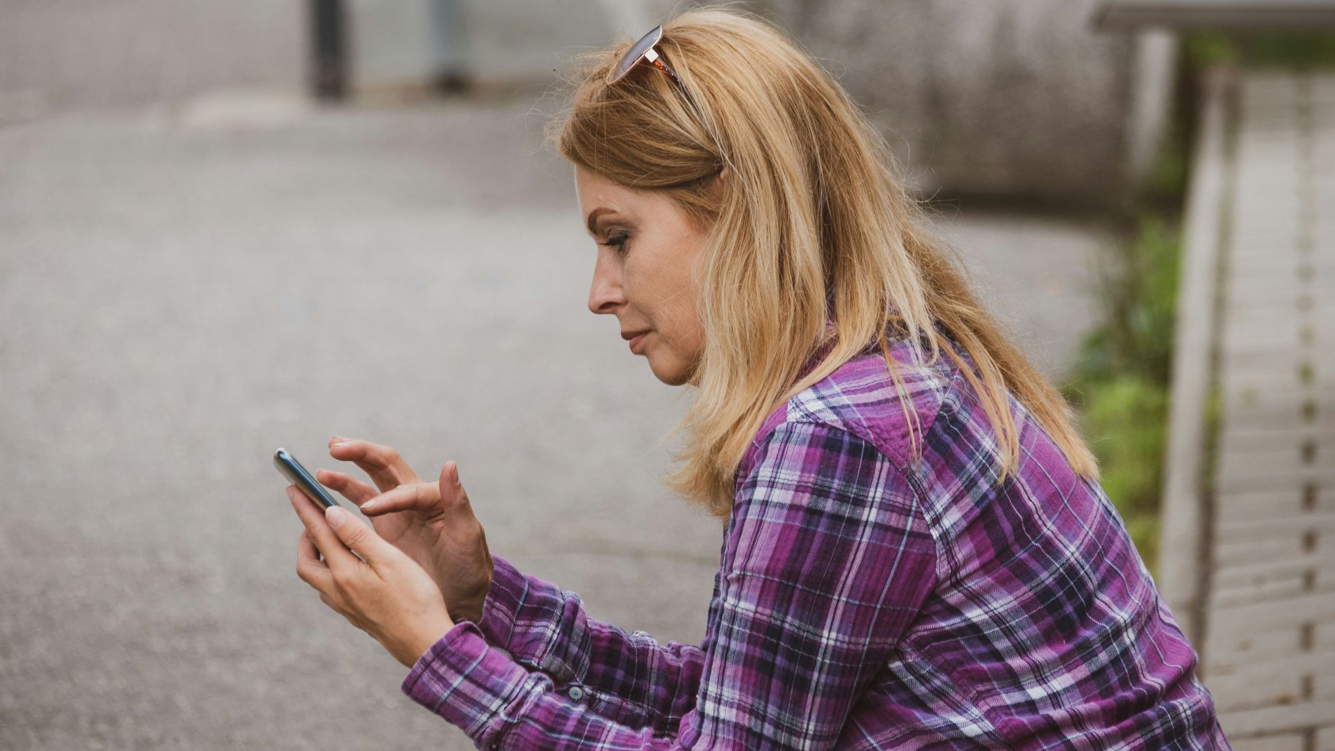 a woman sitting on the ground looking at her cell phone
