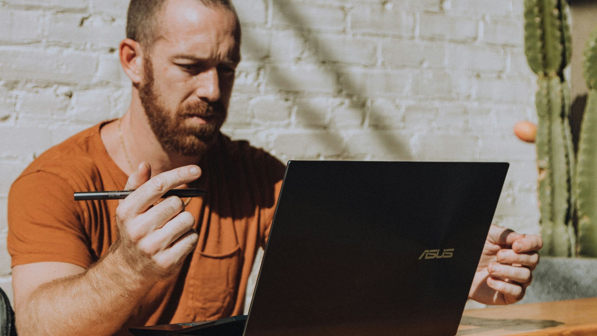 a man sitting at a table using a laptop computer
