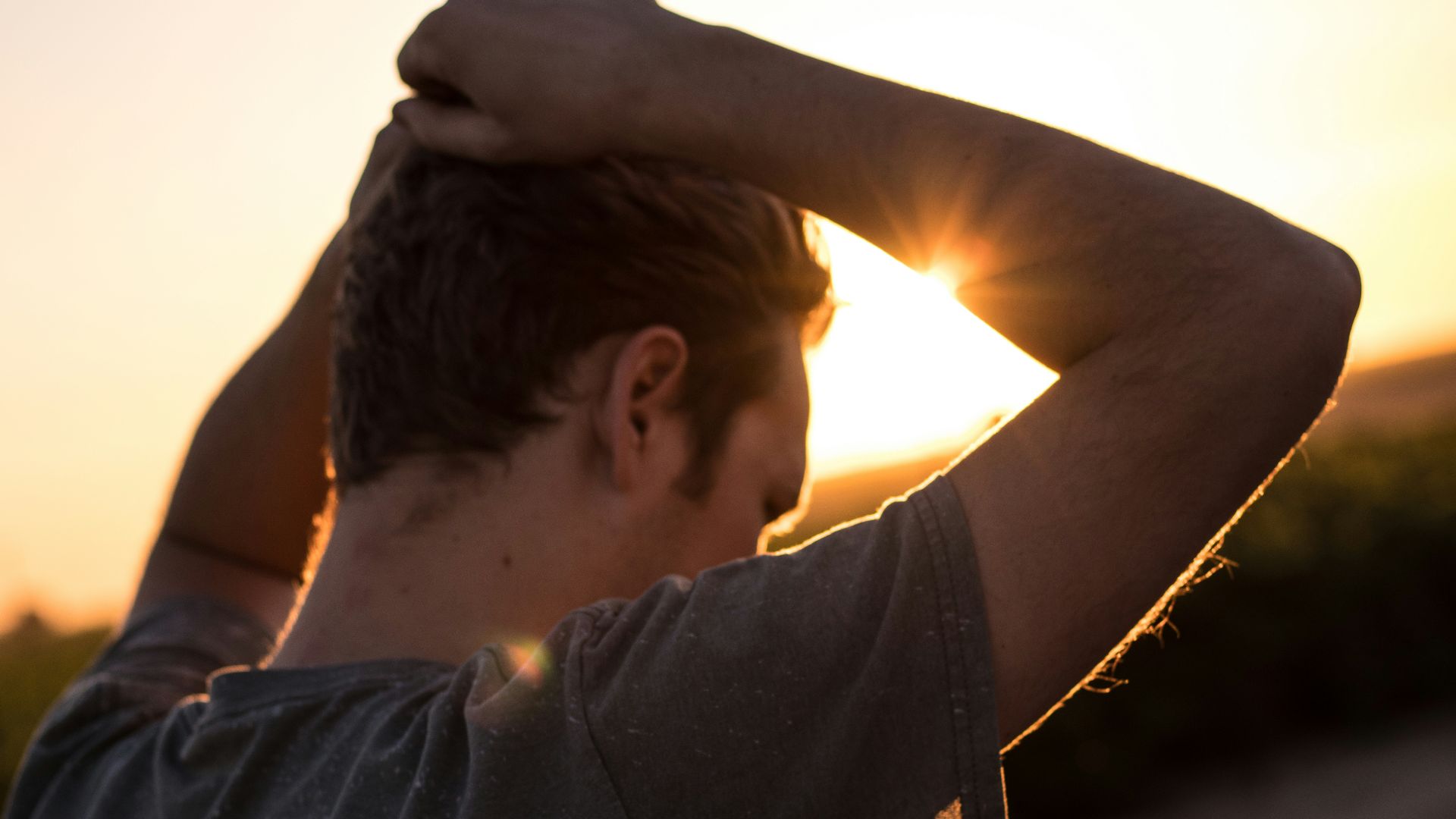 man holding his hair against sunlight