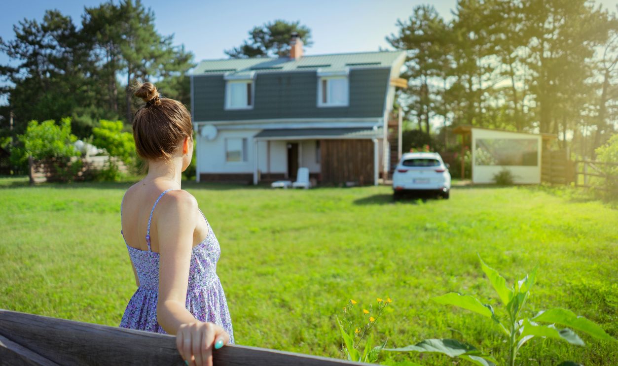 Woman Looking at House with Green Lawn