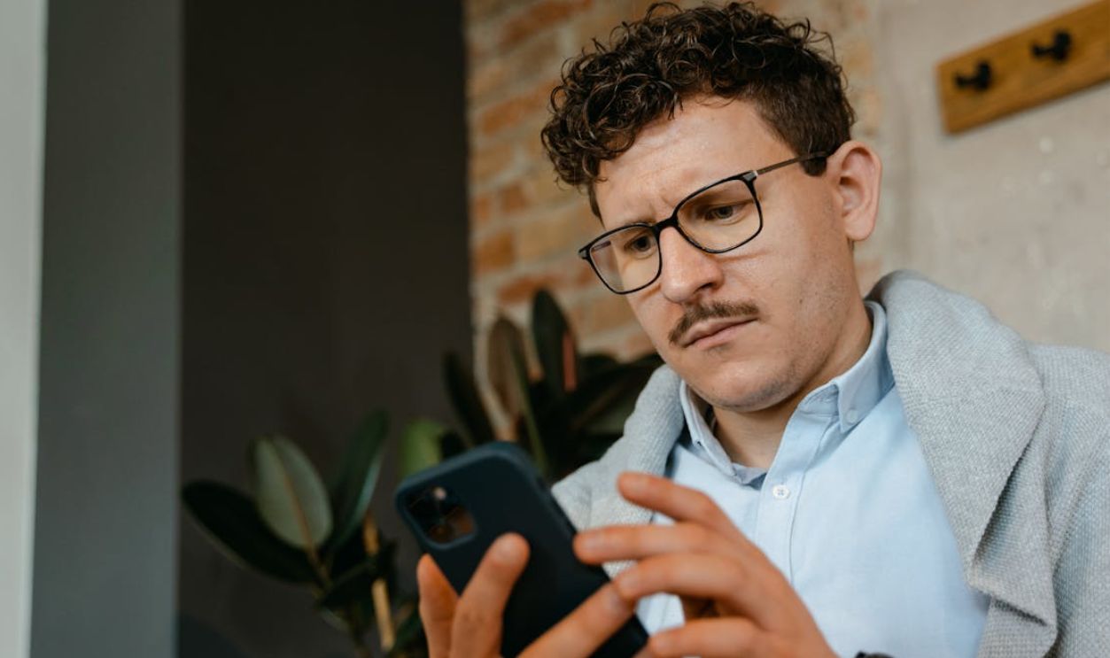 Man With Eyeglasses Using a Smartphone