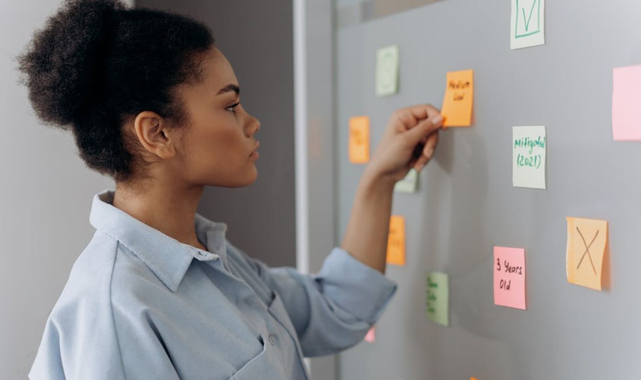 Woman in Blue Long Sleeves Holding Sticky Note