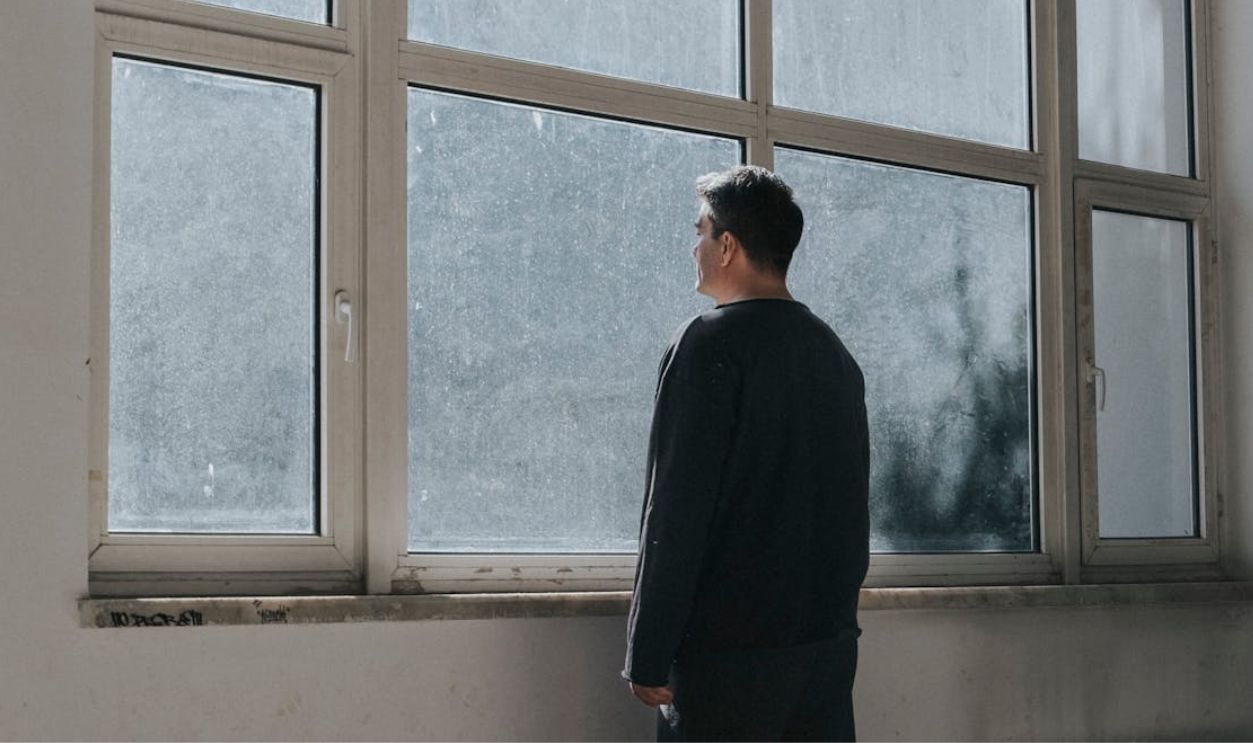 Man Looking Through Windows
