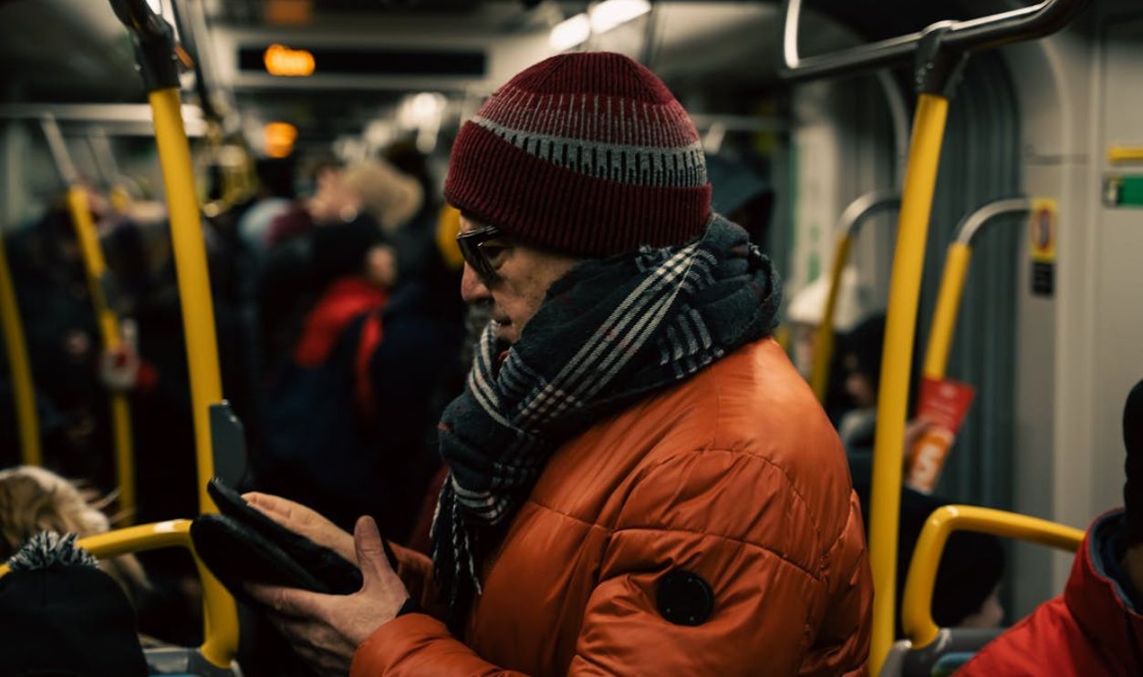 Man in Winter Clothes Riding a Crowded Subway