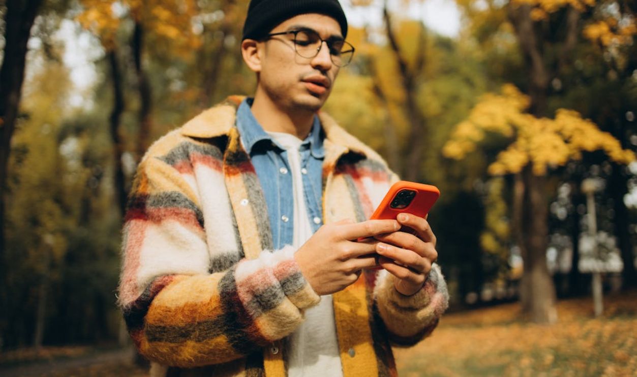 Man in Checkered Jacket Holding a Cellphone