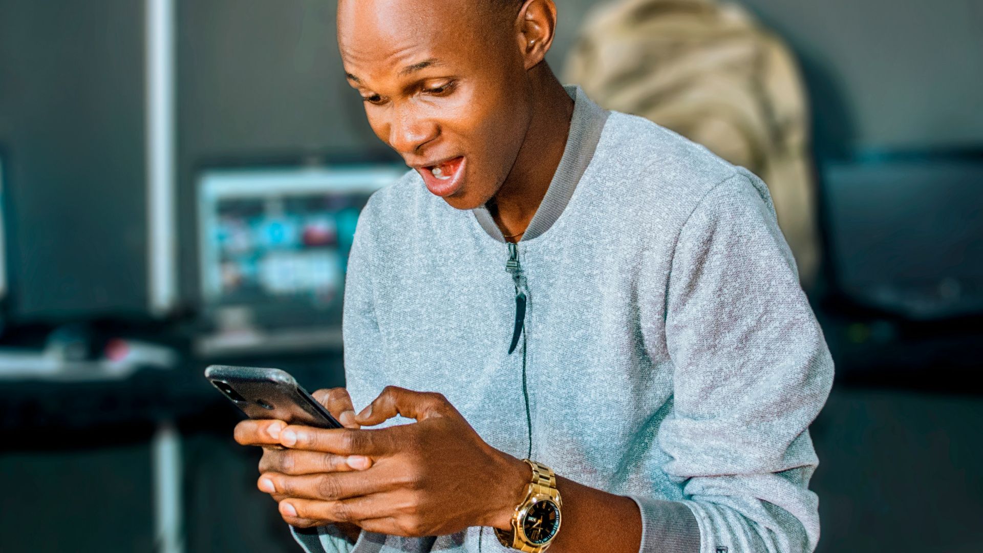 a man looking at his cell phone and laughing