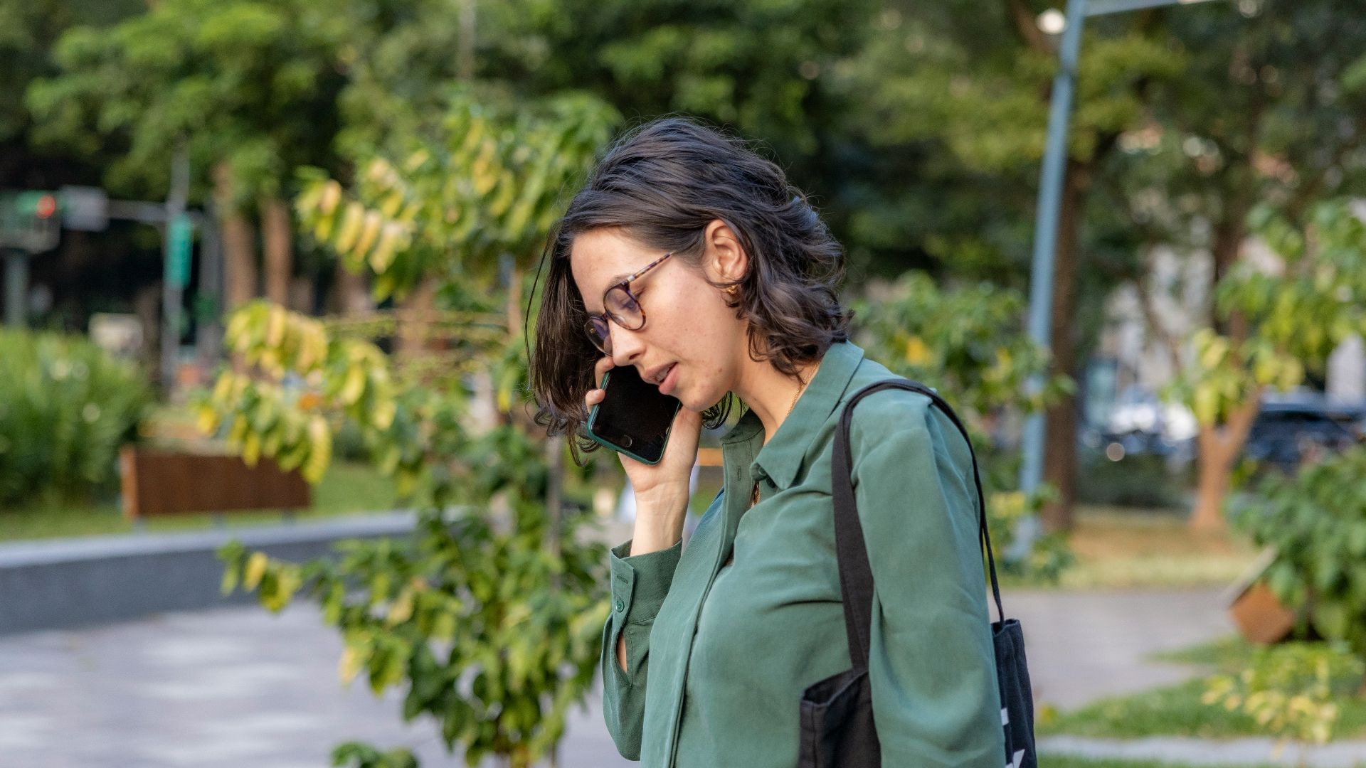 a woman talking on a cell phone in a park