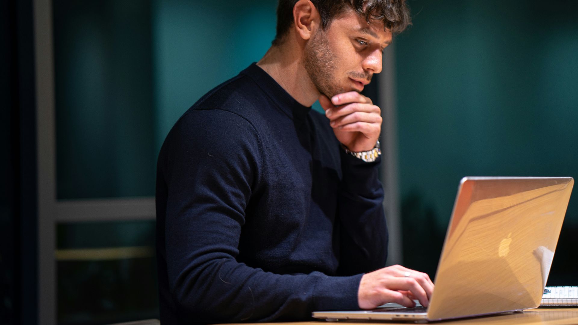 man in black long sleeve shirt sitting in front of macbook