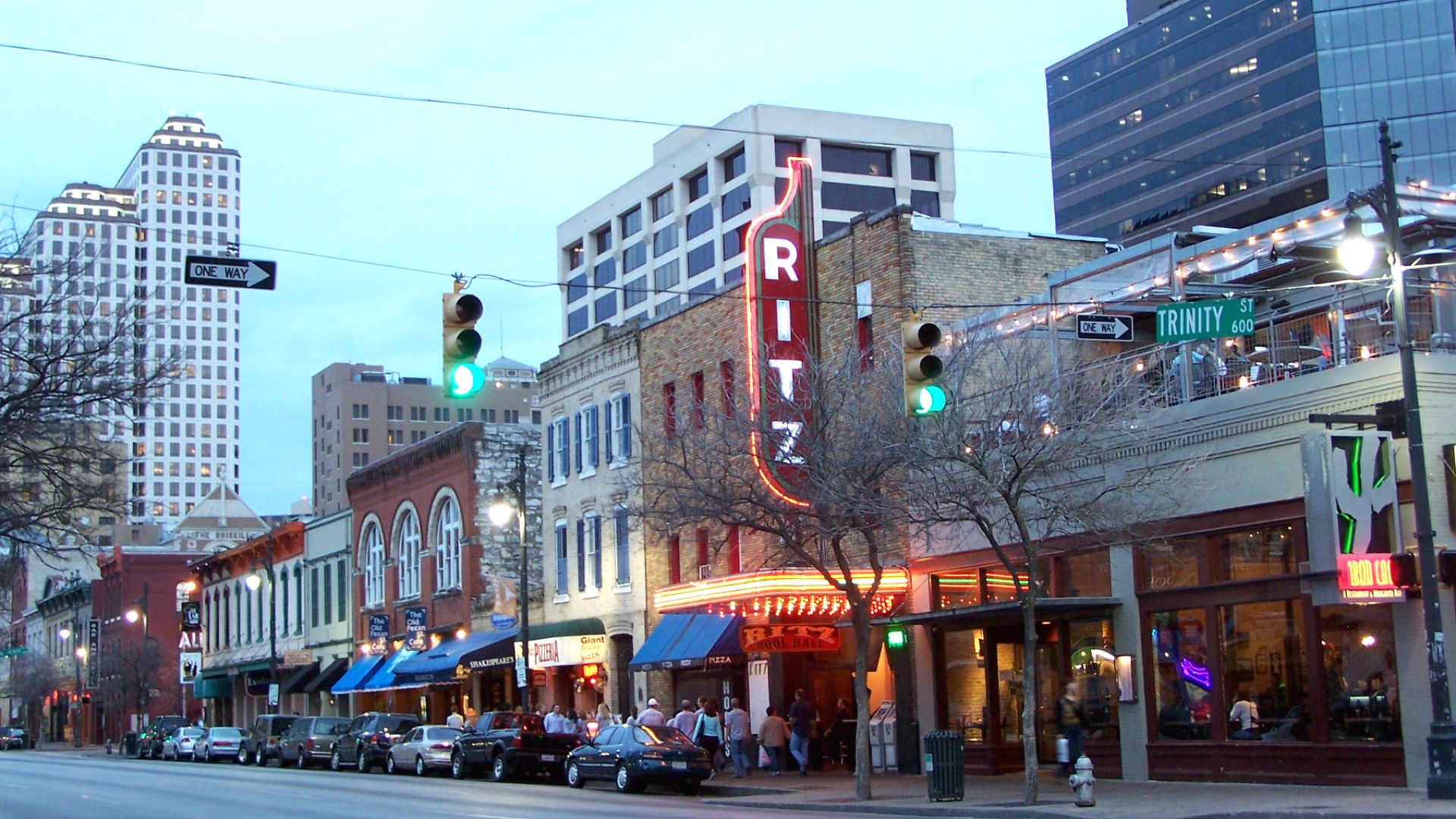 Dusk on Sixth Street at Sixth Street & Trinity Street, Austin, Texas, United States. The area of Sixth Street roughly bounded by Fifth Street, Seventh Street, Lavaca Street and Interstate 35 is known as the Sixth Street Historic District and was listed in the National Register of Historic Places on December 30, 1975.