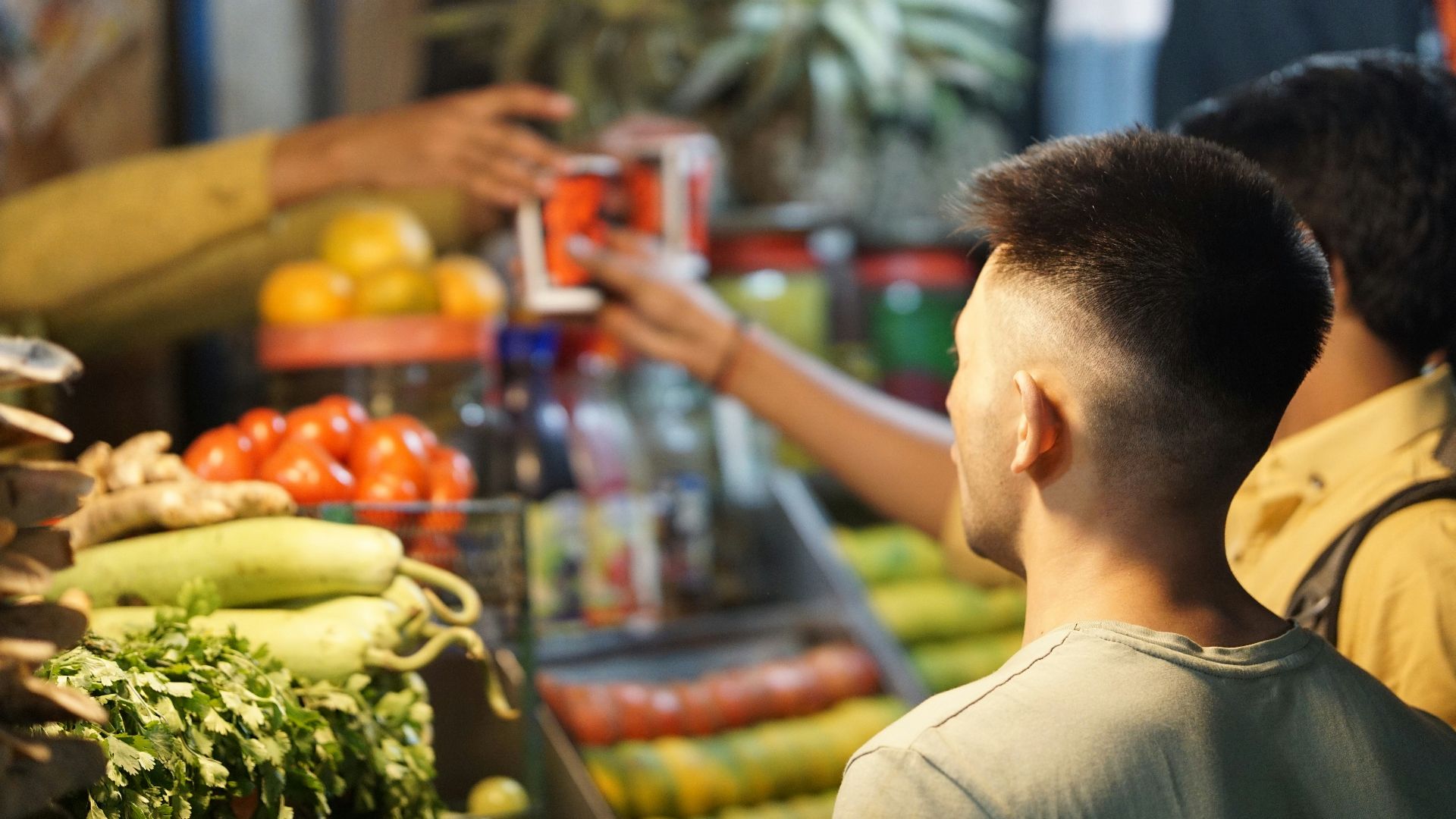 a man standing in front of a display of fruits and vegetables