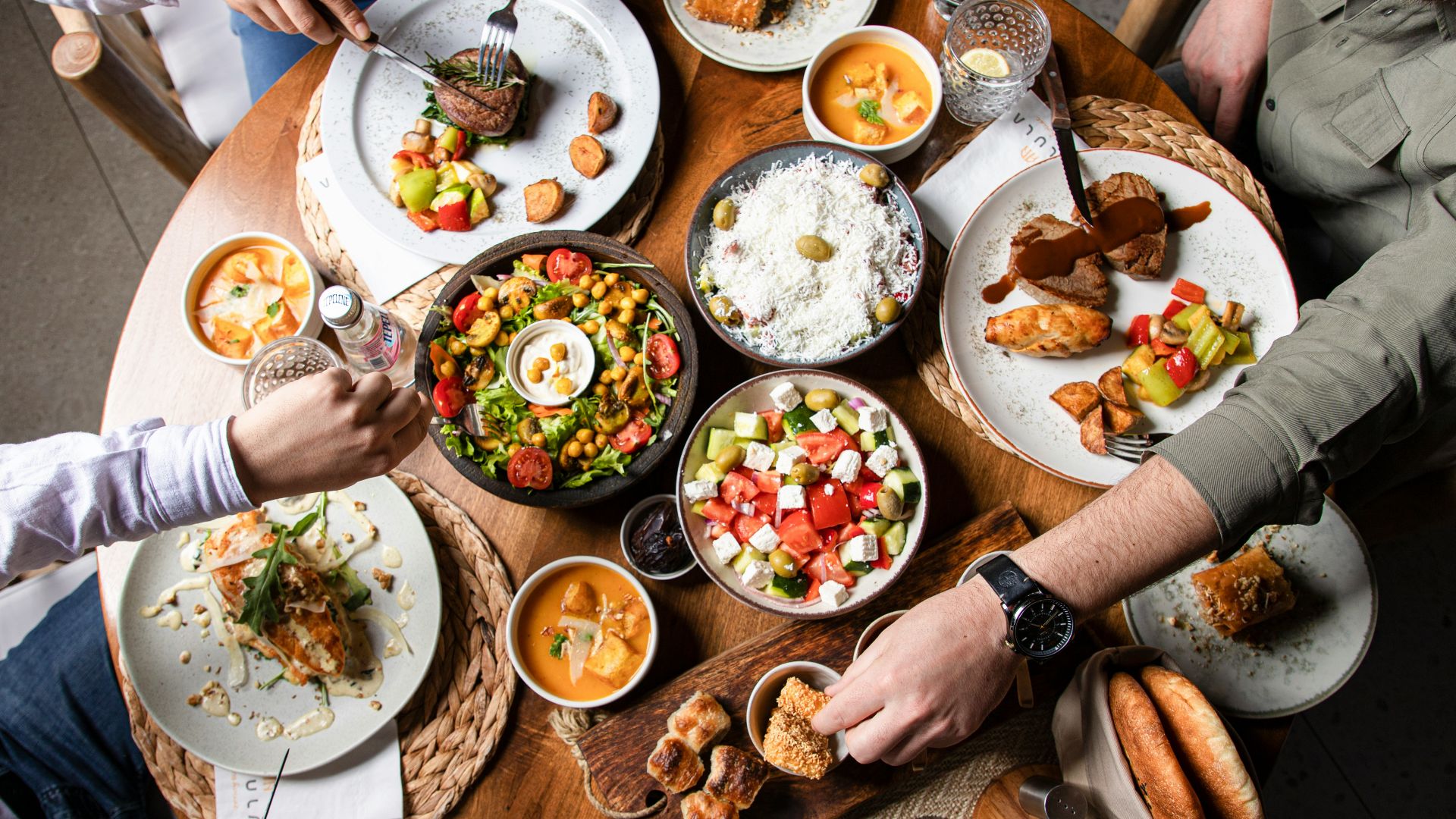 People enjoying a variety of dishes at a round table.