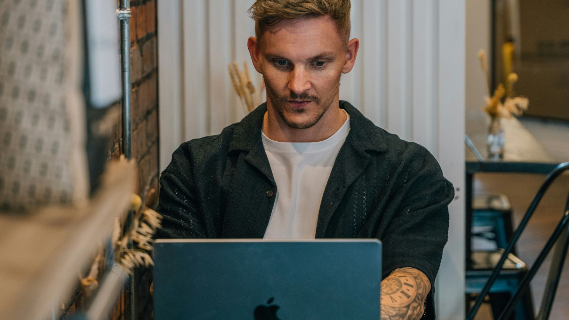 A man sitting at a table using a laptop computer