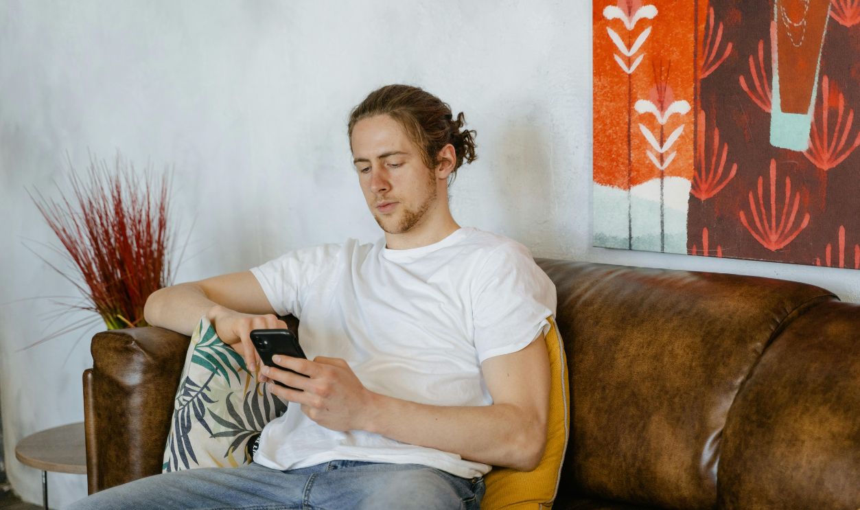 A Man in White Crew Neck T-shirt Sitting on a Sofa