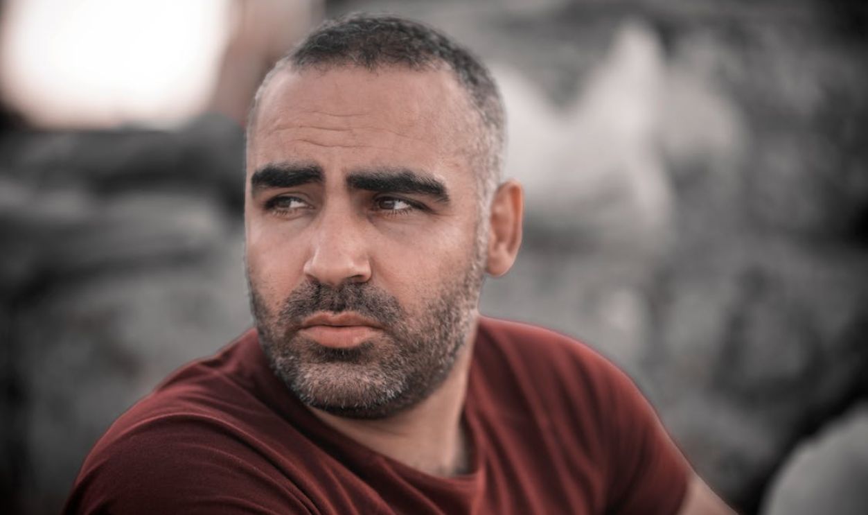 A Close-up Shot of a Bearded Man in Red Shirt