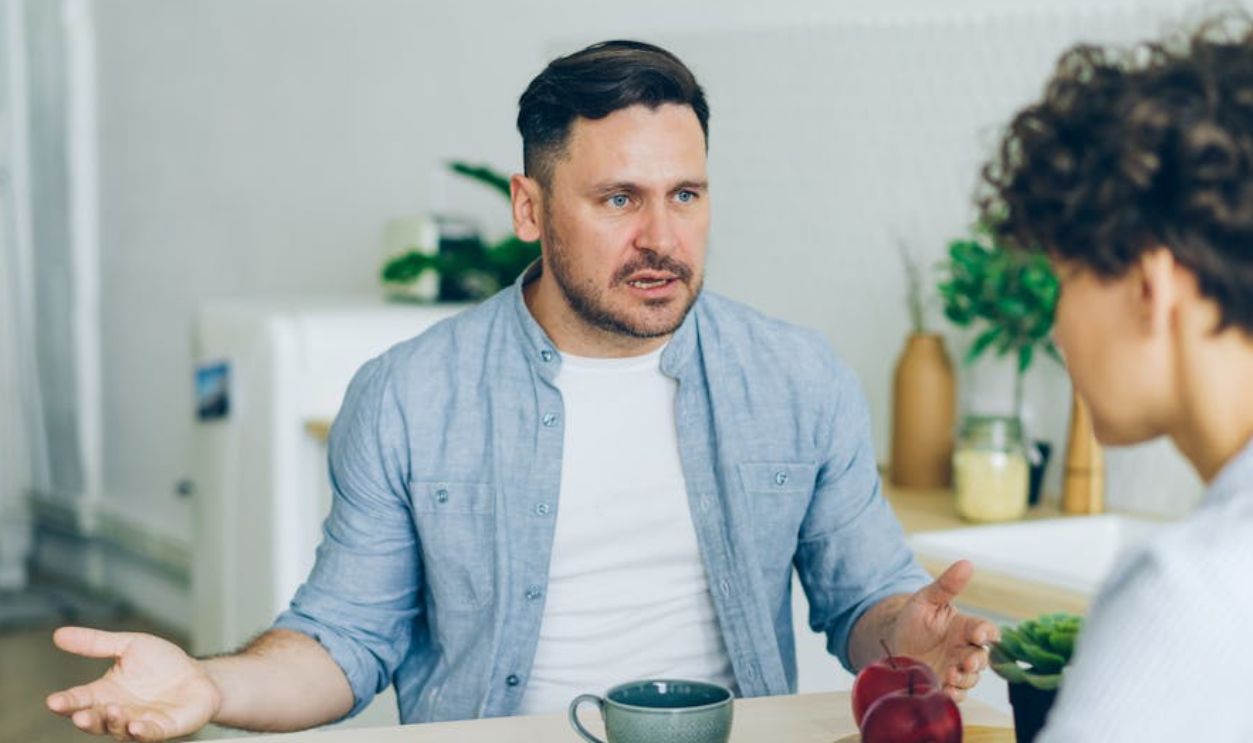 Man Arguing with Woman by Table