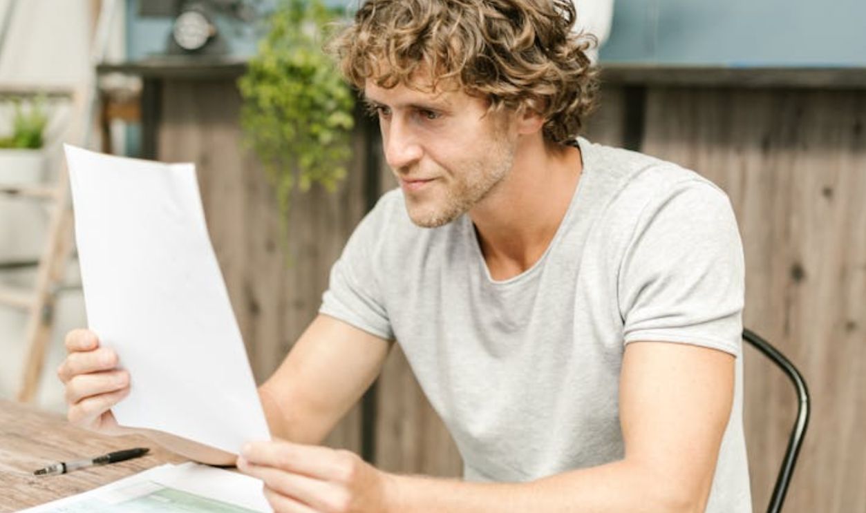 Man in Gray Crew Neck Shirt Reading a Paper