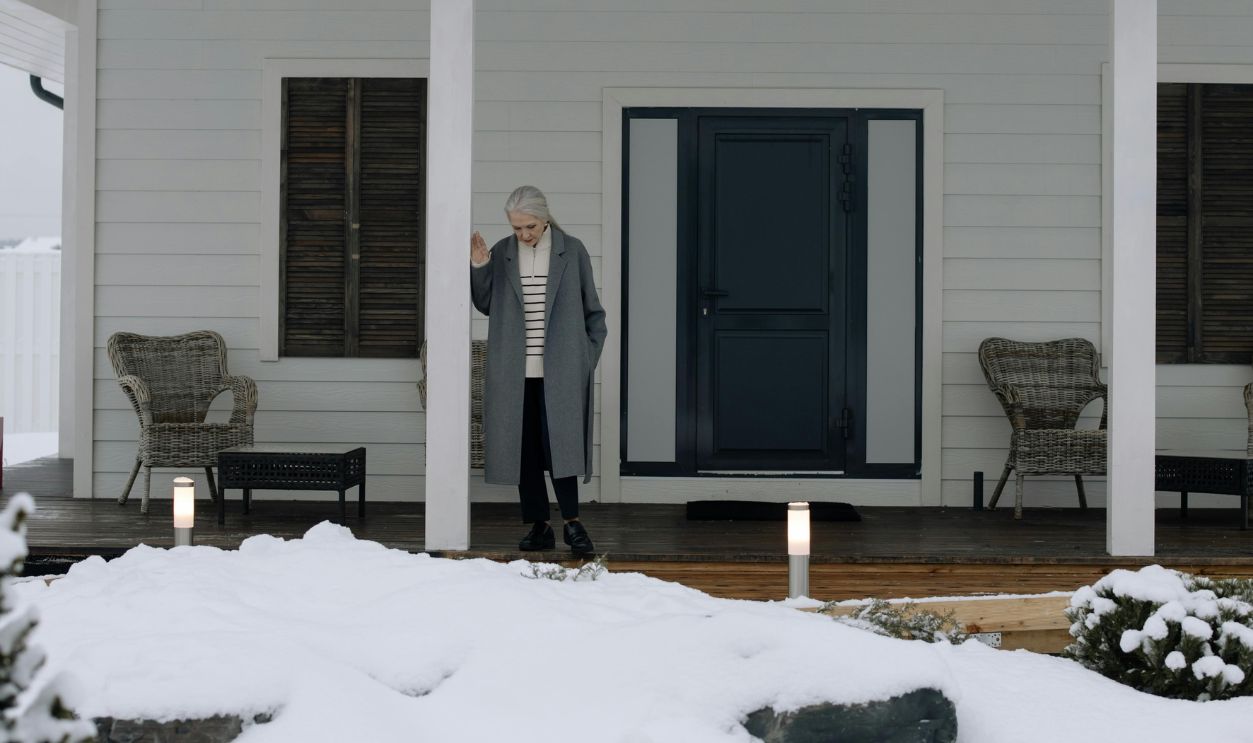 A Woman Standing on Porch of the House