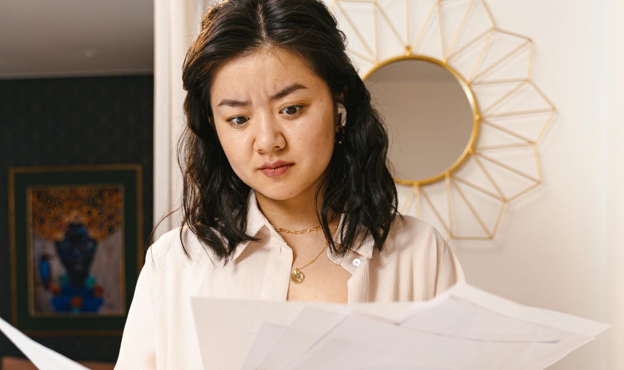Confused Woman Looking at Papers