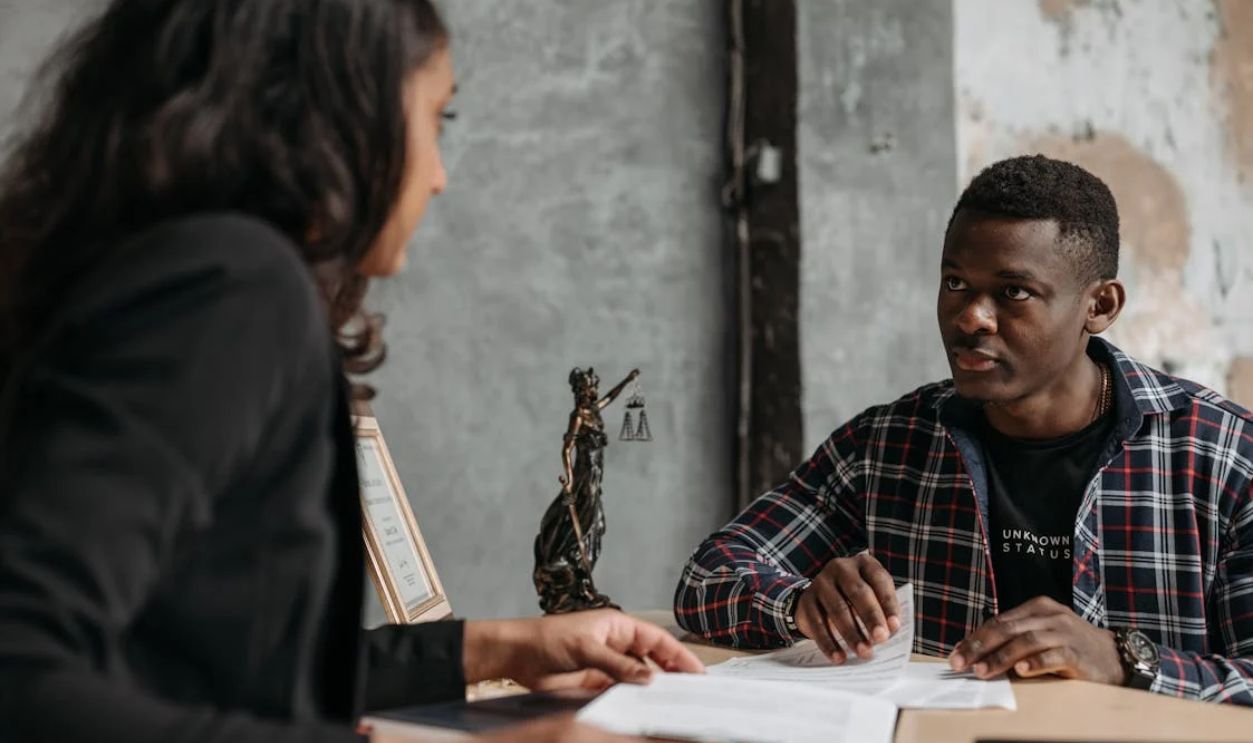 A Man in Checkered Long Sleeves Talking to His Lawyer