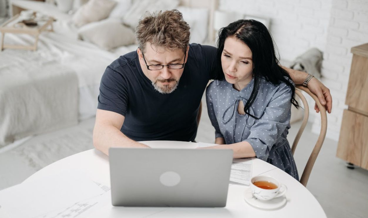 A Man and a Woman using a Laptop Together