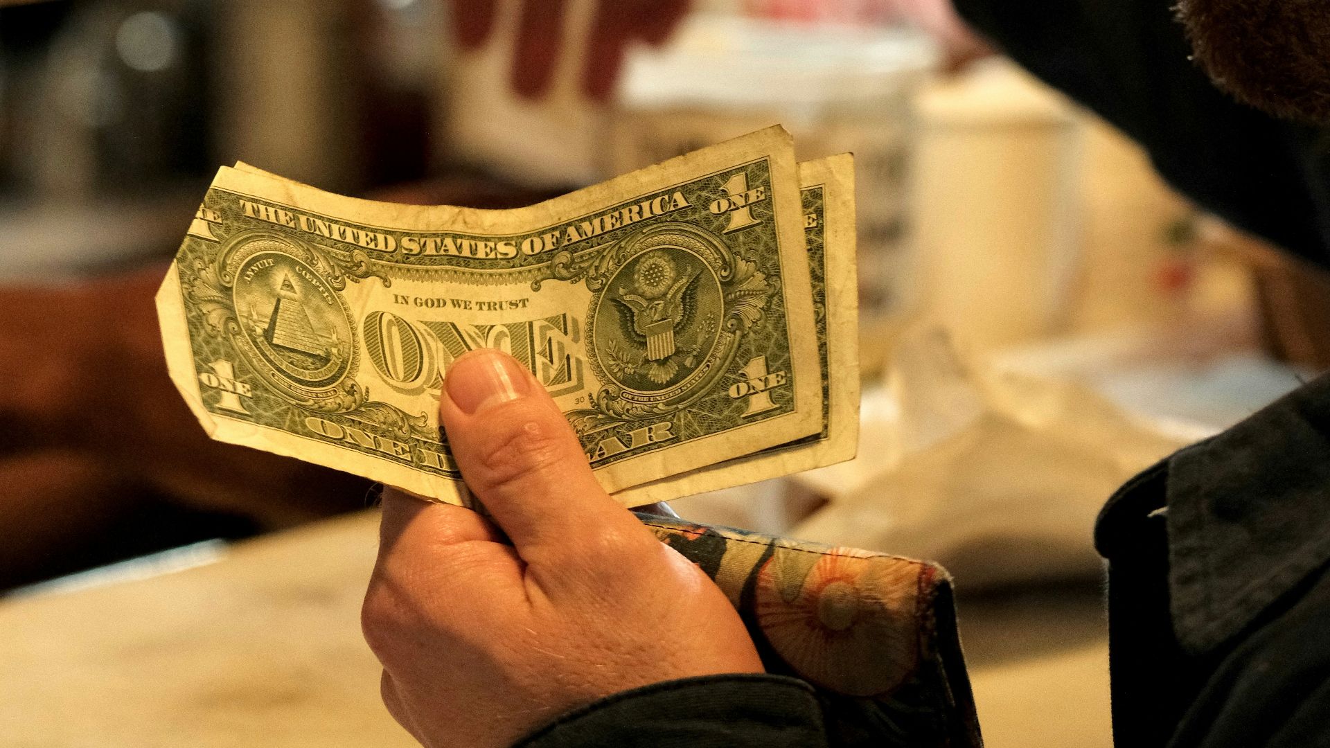Man handing cash to someone at a counter