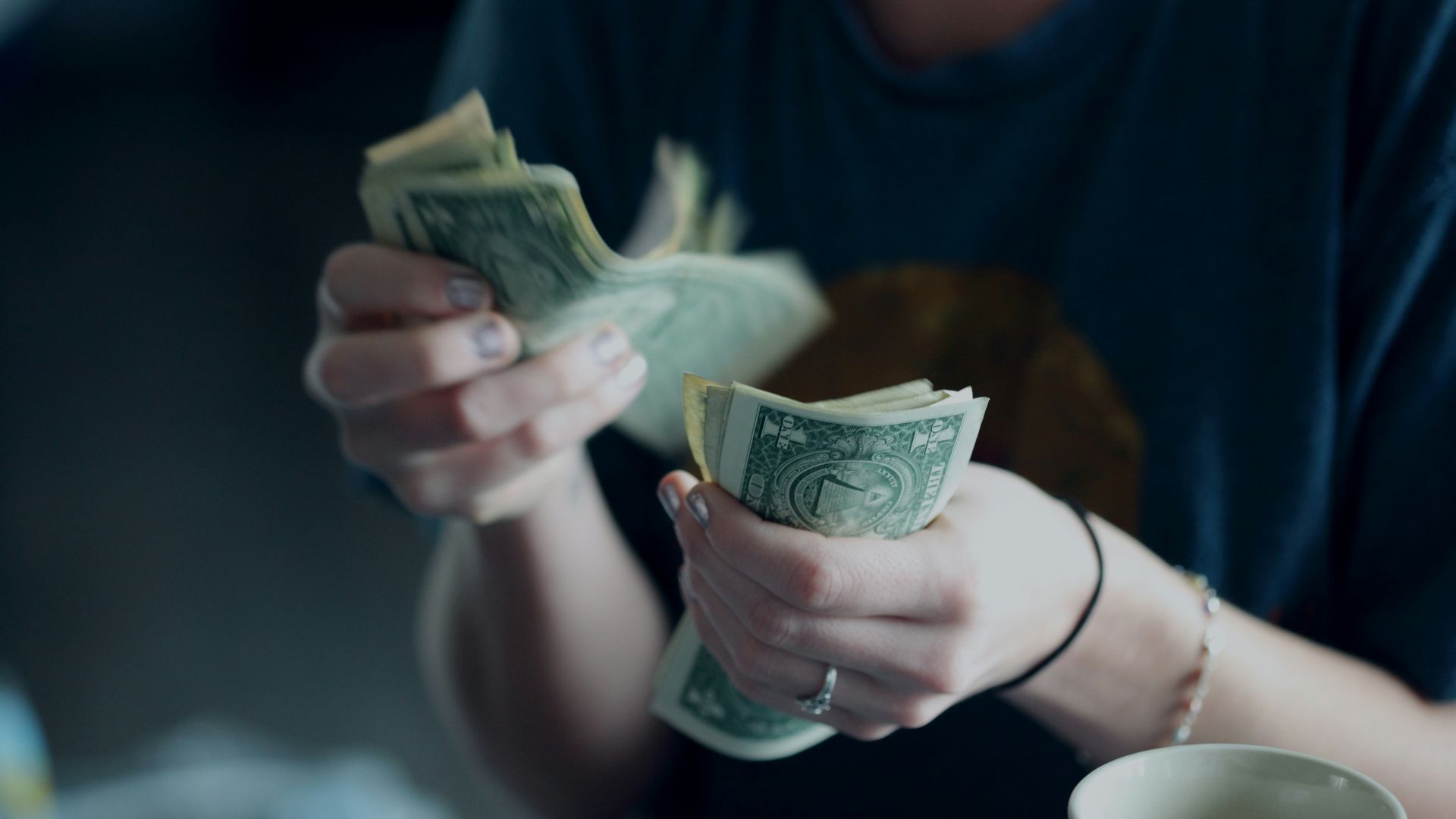 focus photography of person counting dollar banknotes