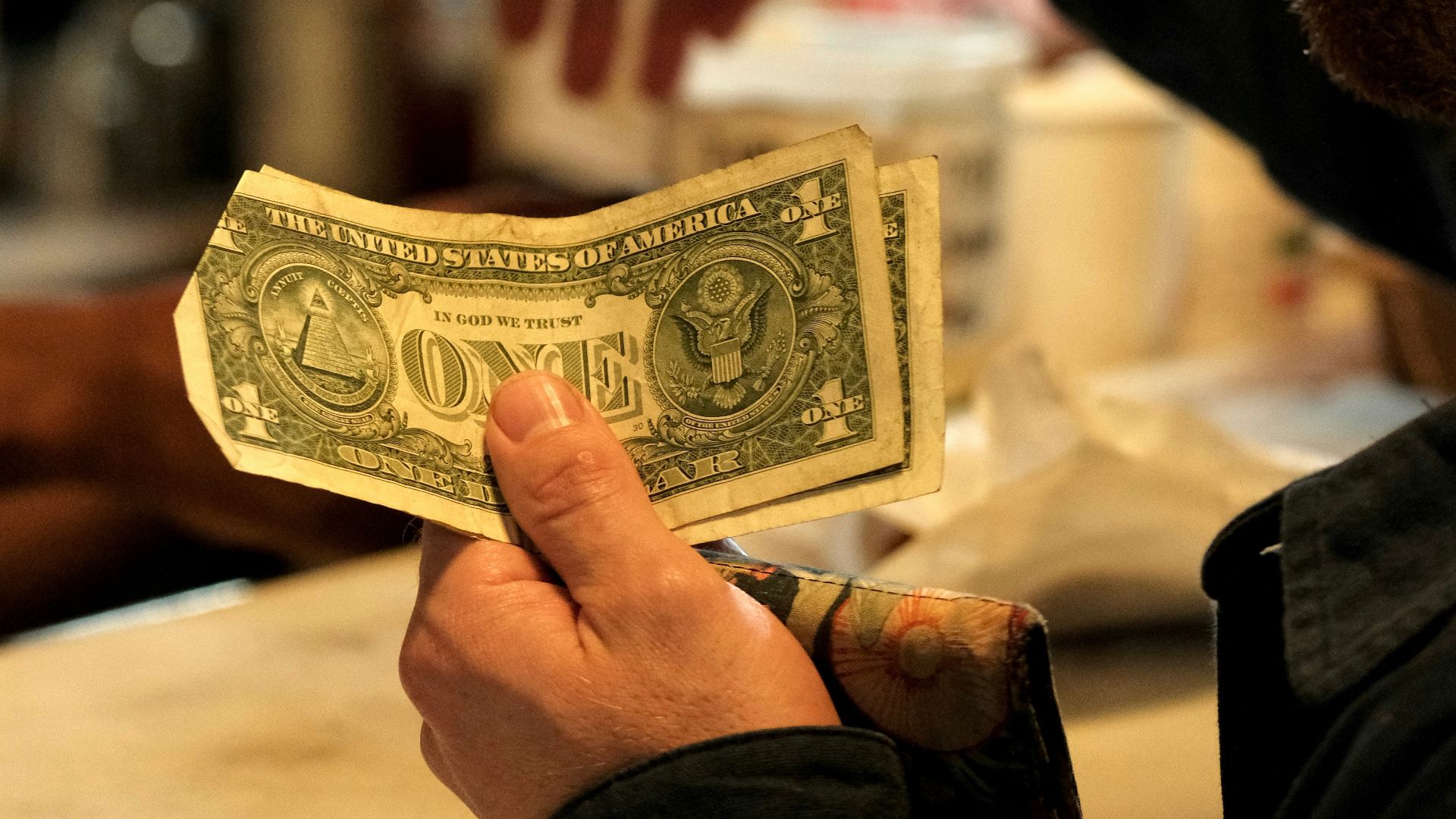 Man handing cash to someone at a counter