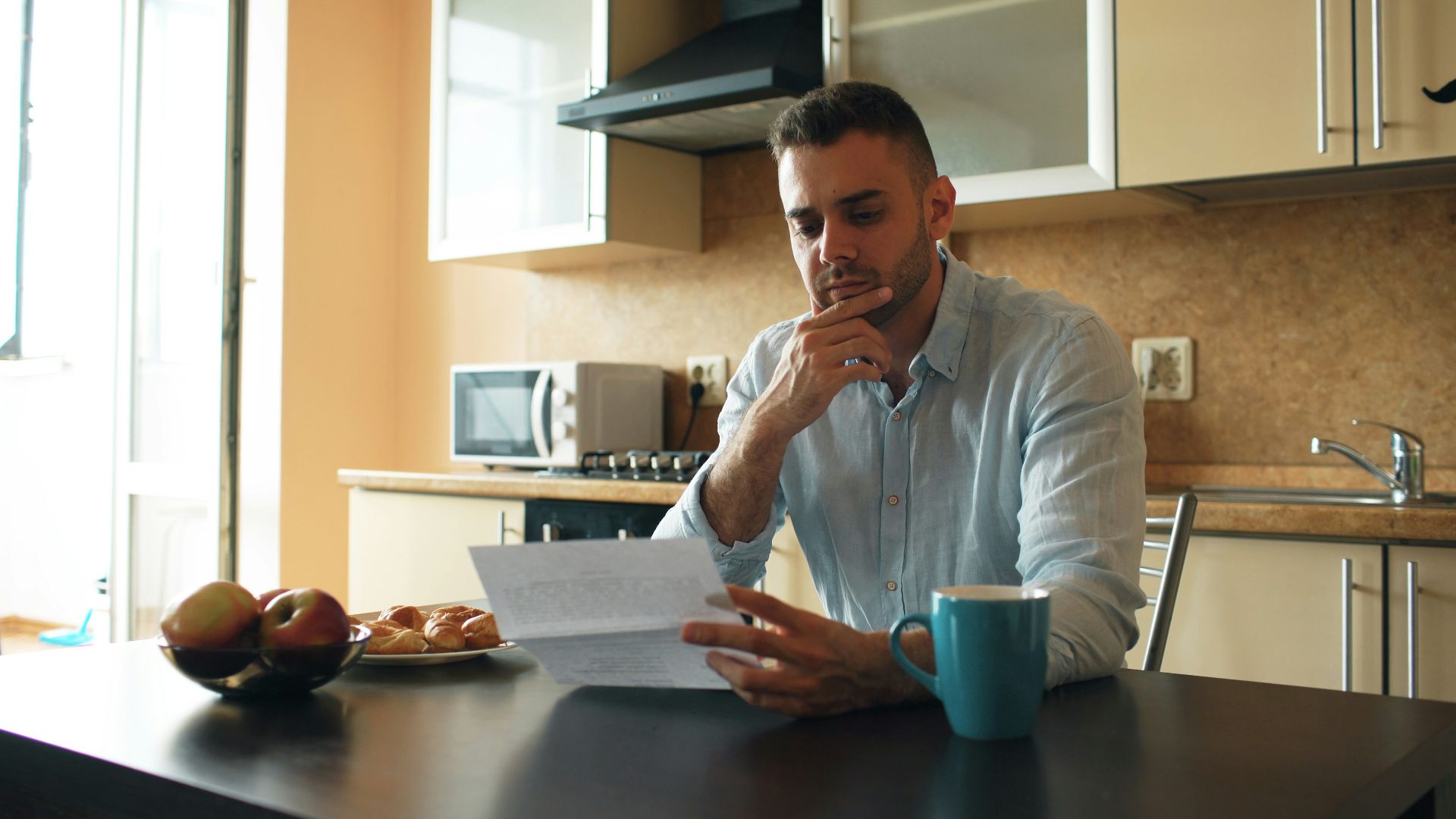Man reading a document in a kitchen